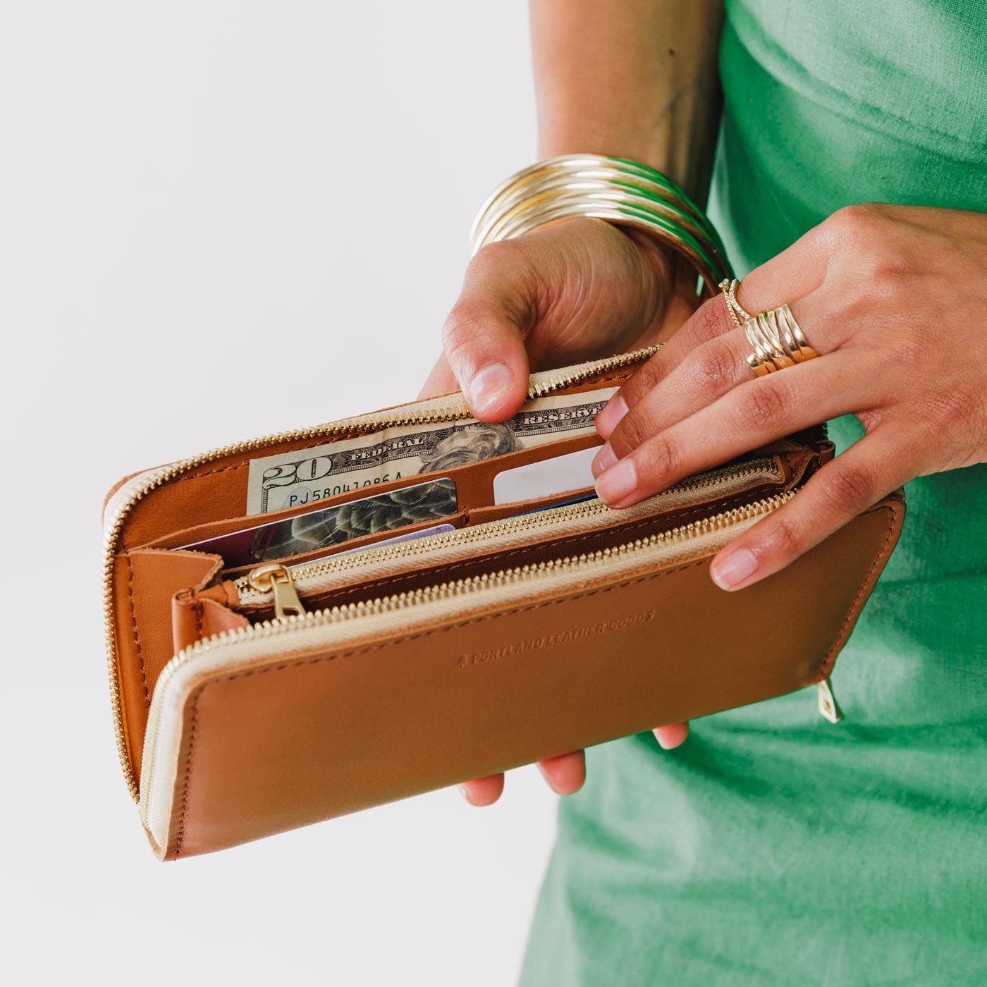 Biscuit | Model holding large accordion leather wallet with zipper open