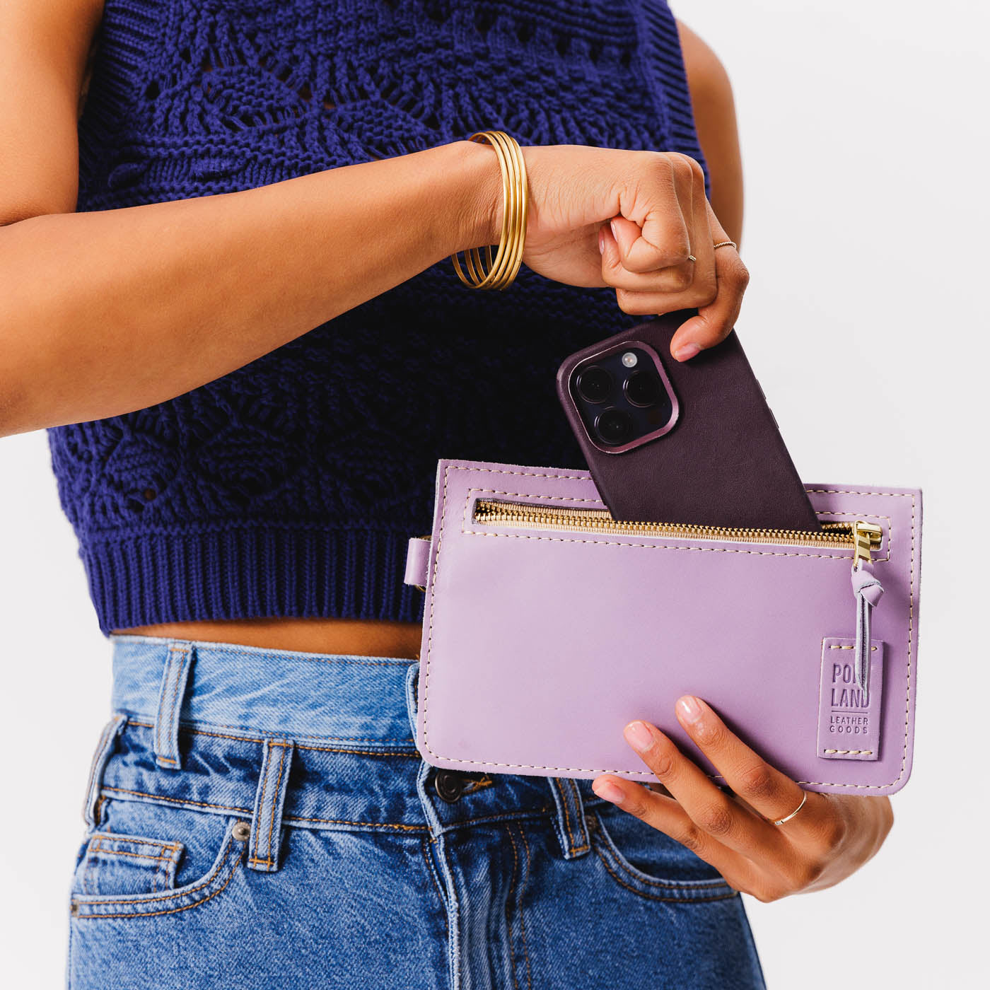 Lavender | Model holding flat leather pouch with zipper and wristlet