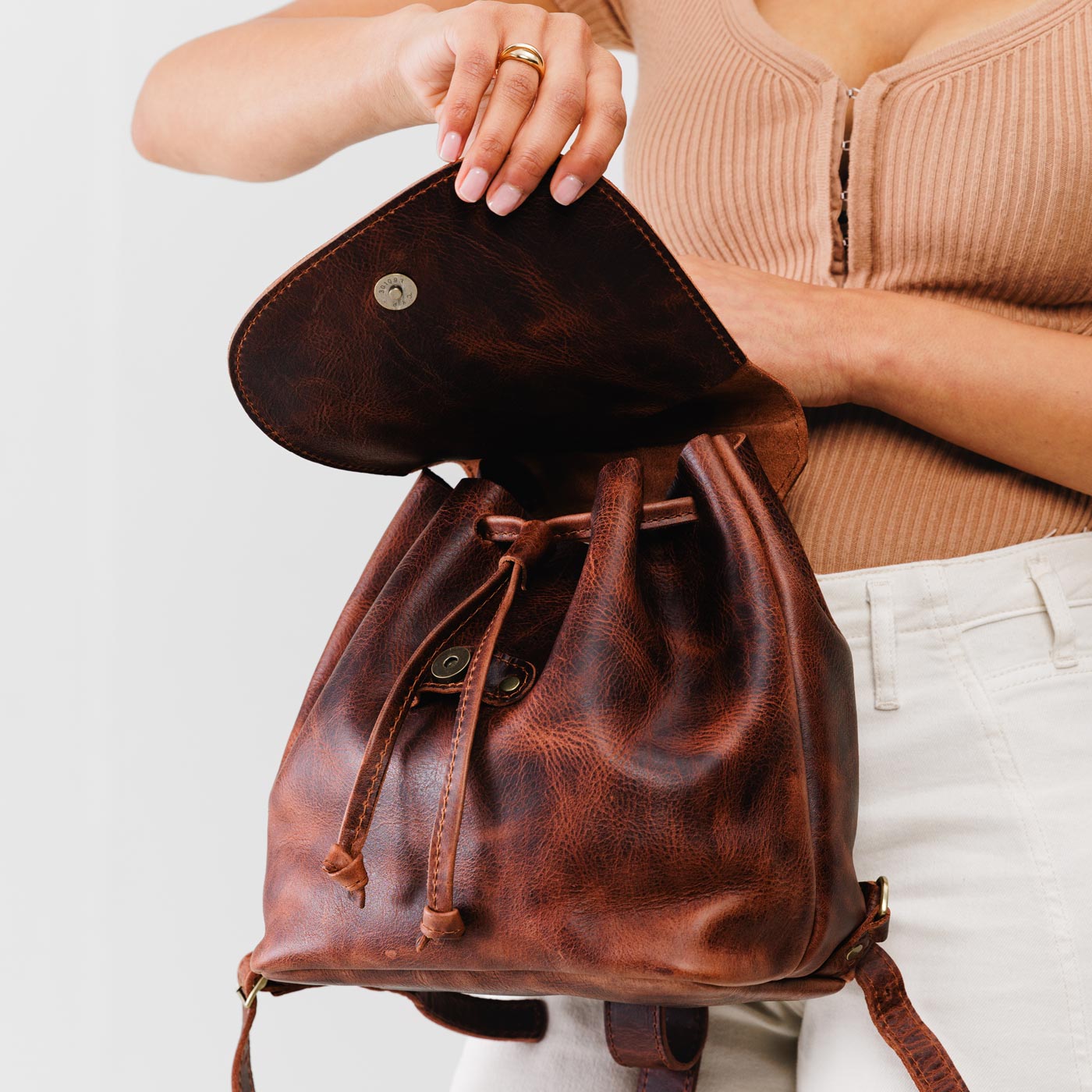 All Color: Lava | Model holding slouchy leather bucket backpack