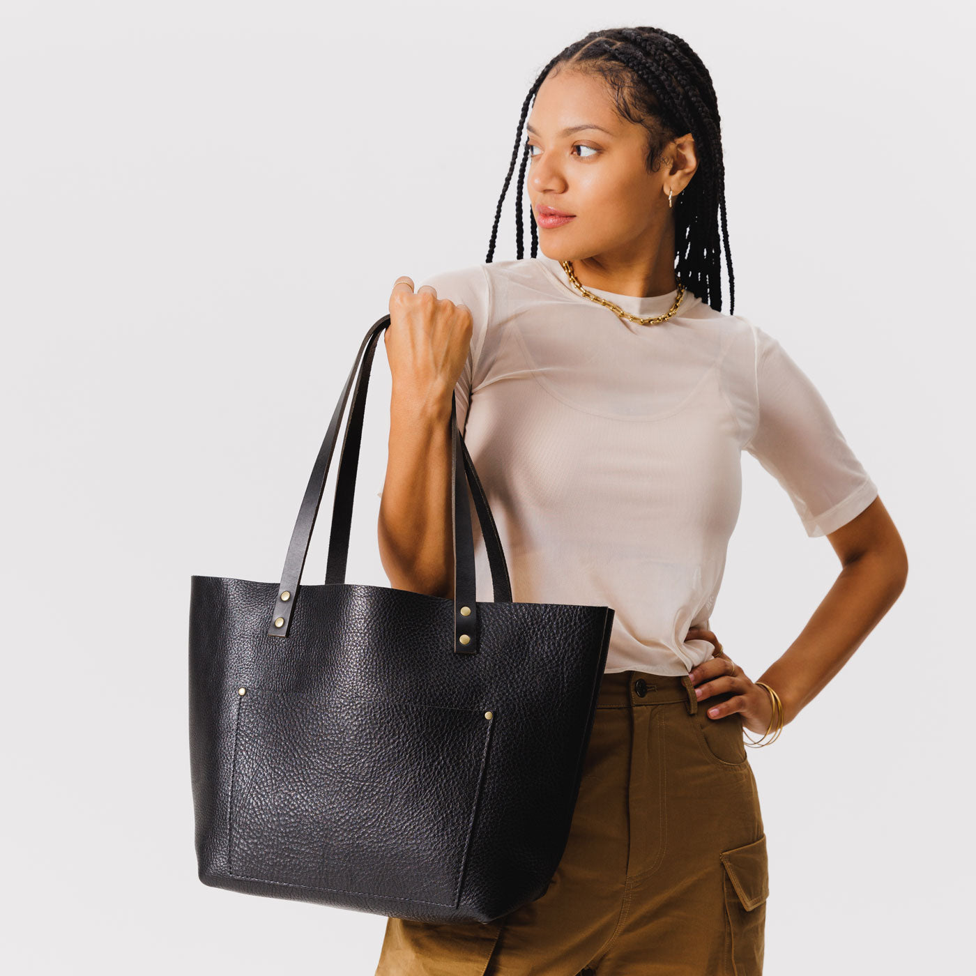 Pebbled--black*Classic | Model holding large leather tote bag with sturdy bridle handles and front pocket