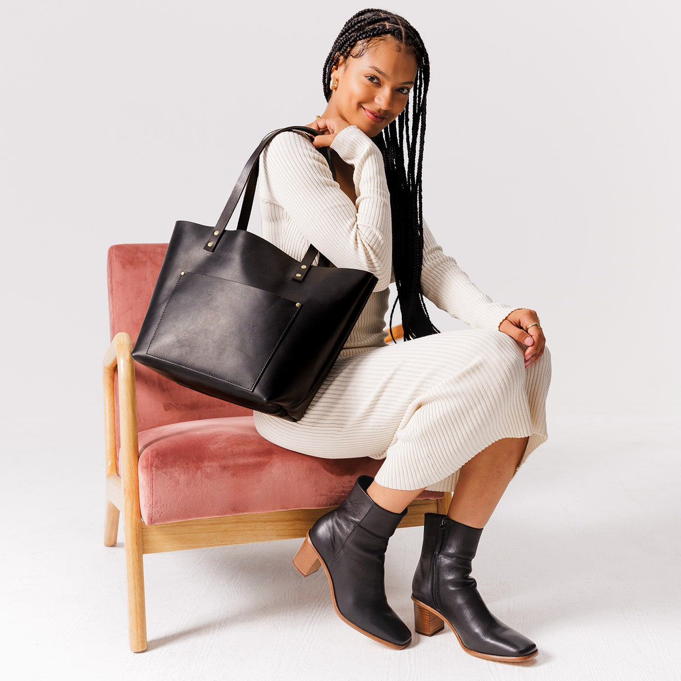 Black Classic | Model holding large leather tote bag with sturdy bridle handles and front pocket