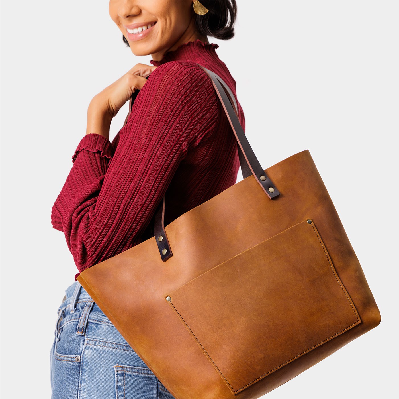 Dakota Classic | Model holding large leather tote bag with sturdy bridle handles and front pocket