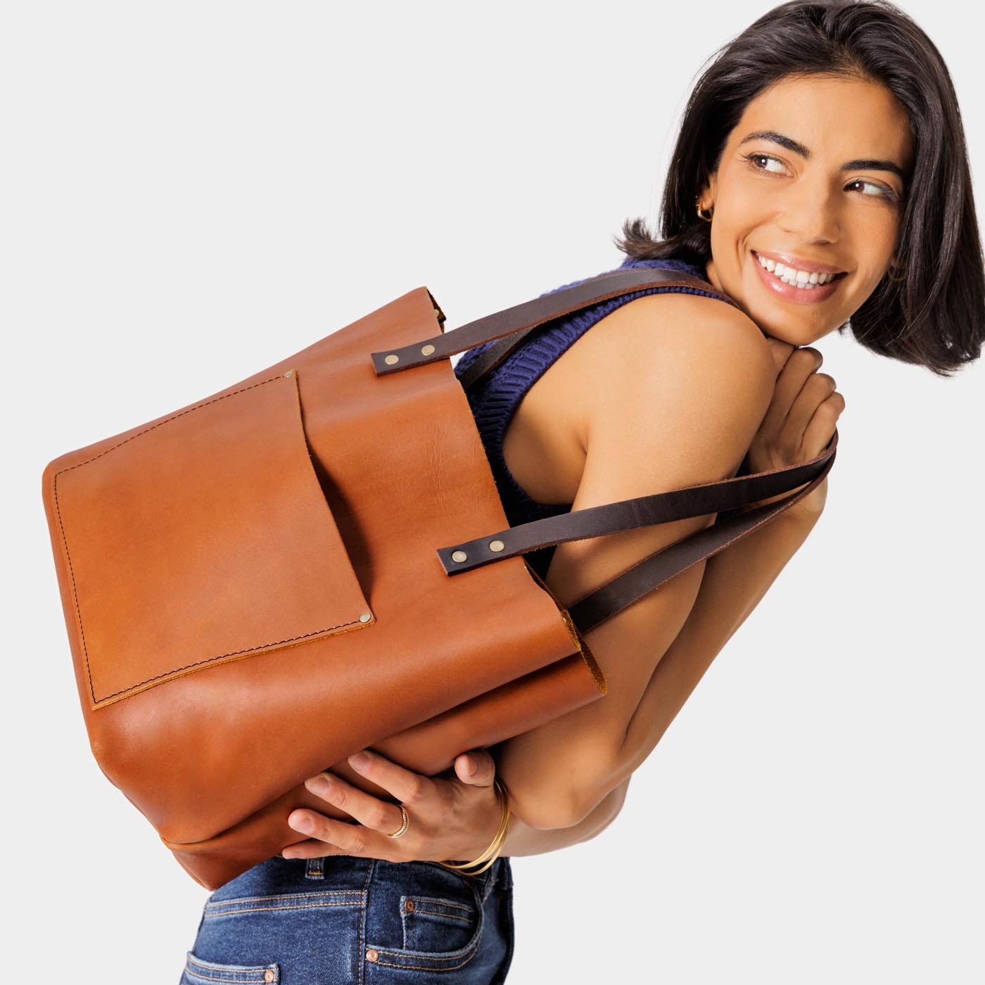 Honey*Classic | Model holding large leather tote bag with sturdy bridle handles and front pocket