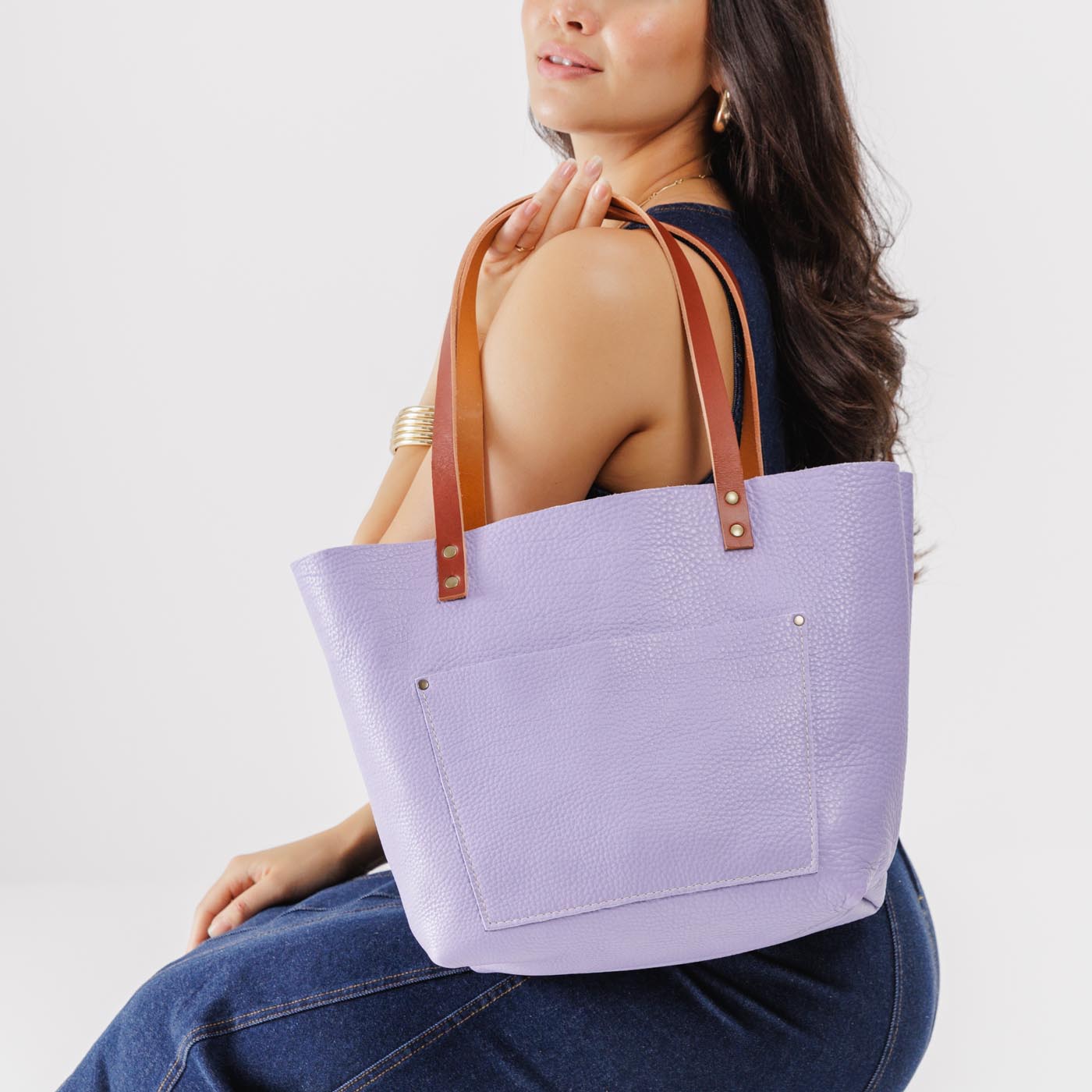 Wisteria Classic | Model holding large leather tote bag with sturdy bridle handles and front pocket