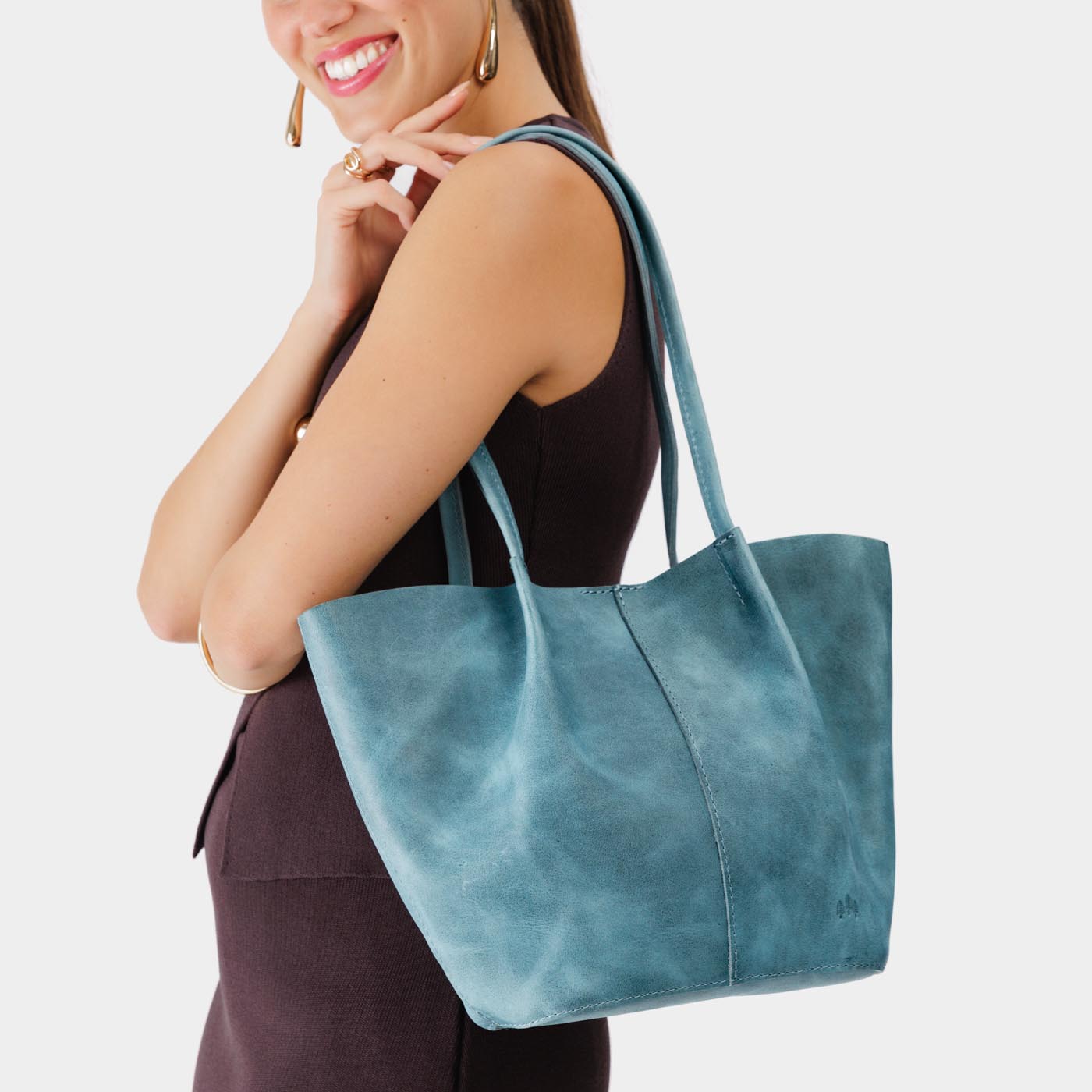 Aqua*Large | Model holding wide bucket shaped tote bag with matching leather handles