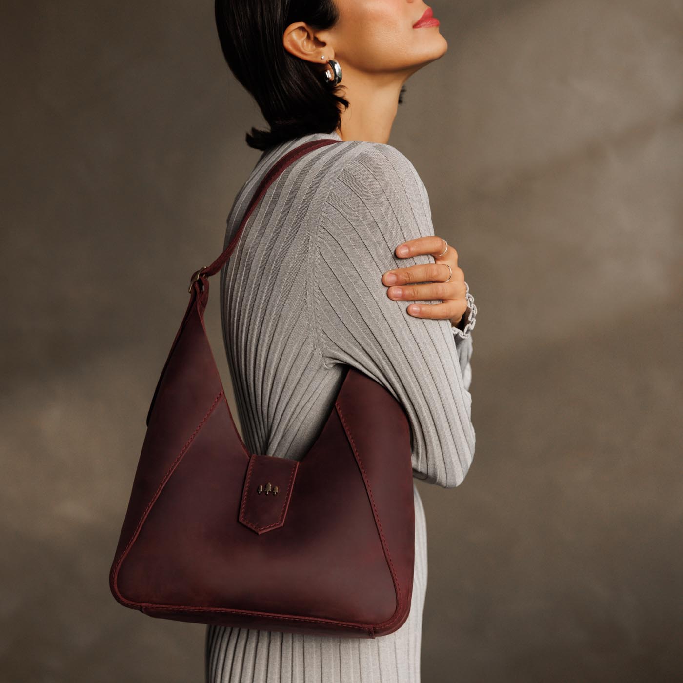 Merlot | Model wearing structured hobo shoulder bag with adjustable strap and magnetic closure