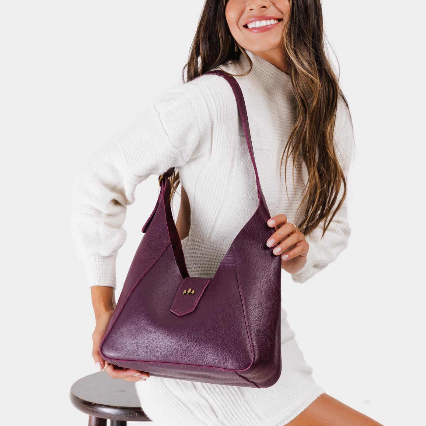 Plum | Model wearing structured hobo shoulder bag with adjustable strap and magnetic closure