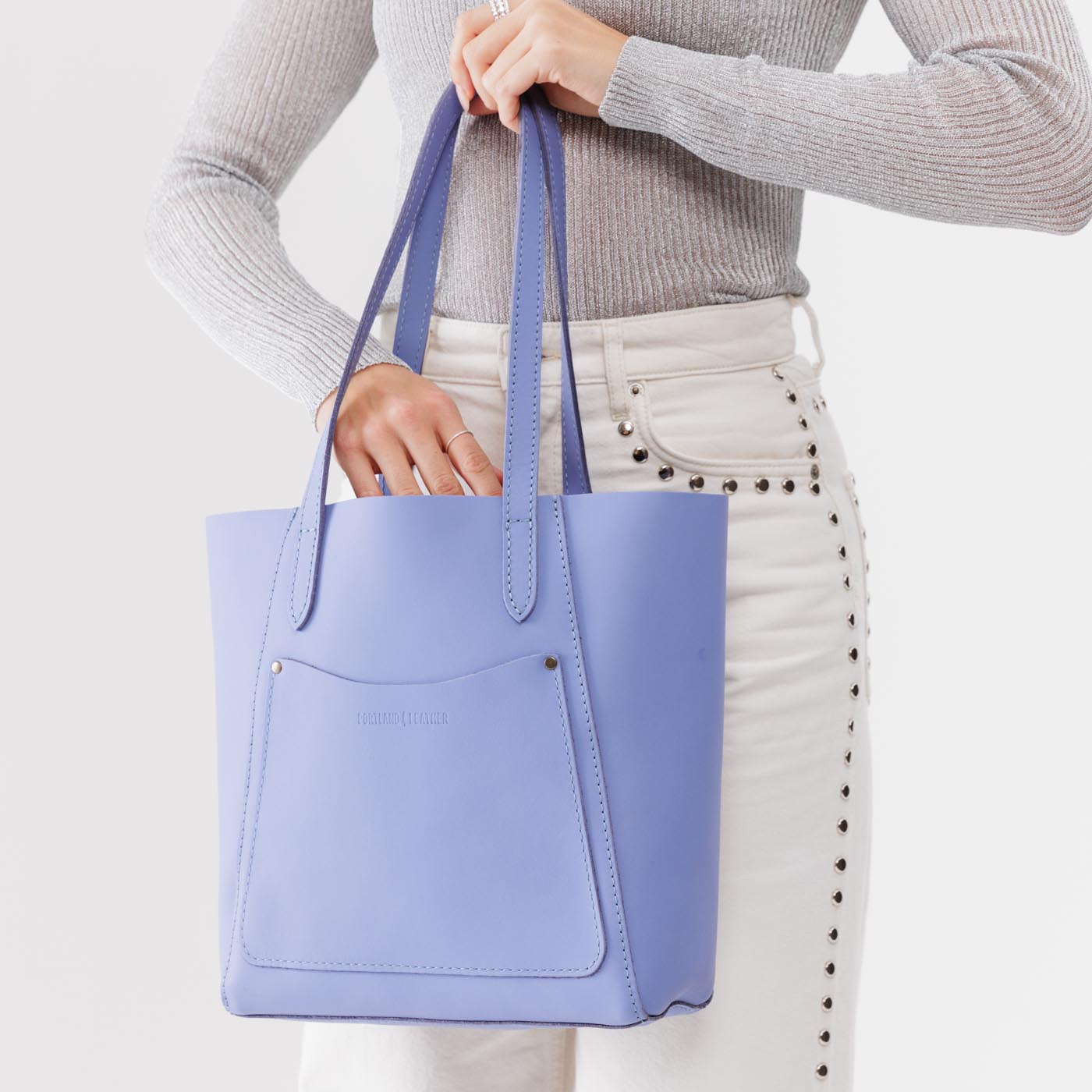 Jacaranda*Large | Model holding dual shoulder strap tote bag with an exterior pocket