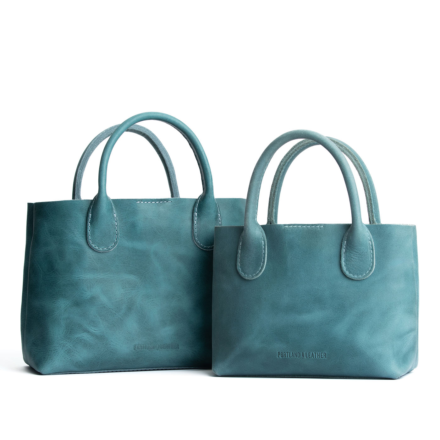 Aqua | Side by side of both tote purses with structured leather handles and crossbody strap