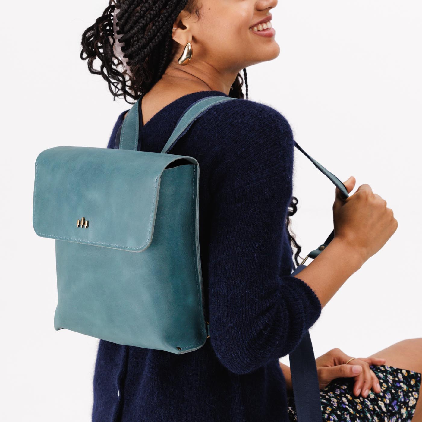 Aqua | Model wearing rectangular backpack with leather lined nylon straps and magnetic flap closure