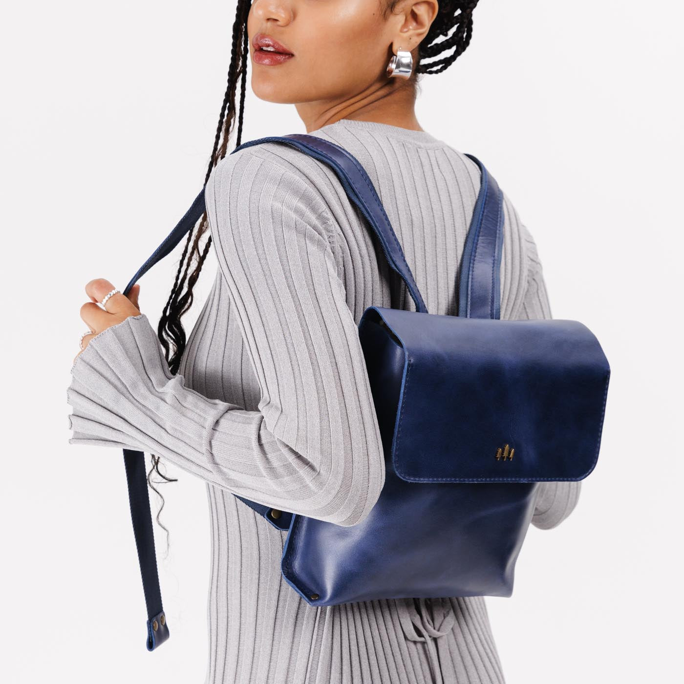 Cowboy Blue | Model wearing rectangular backpack with leather lined nylon straps and magnetic flap closure