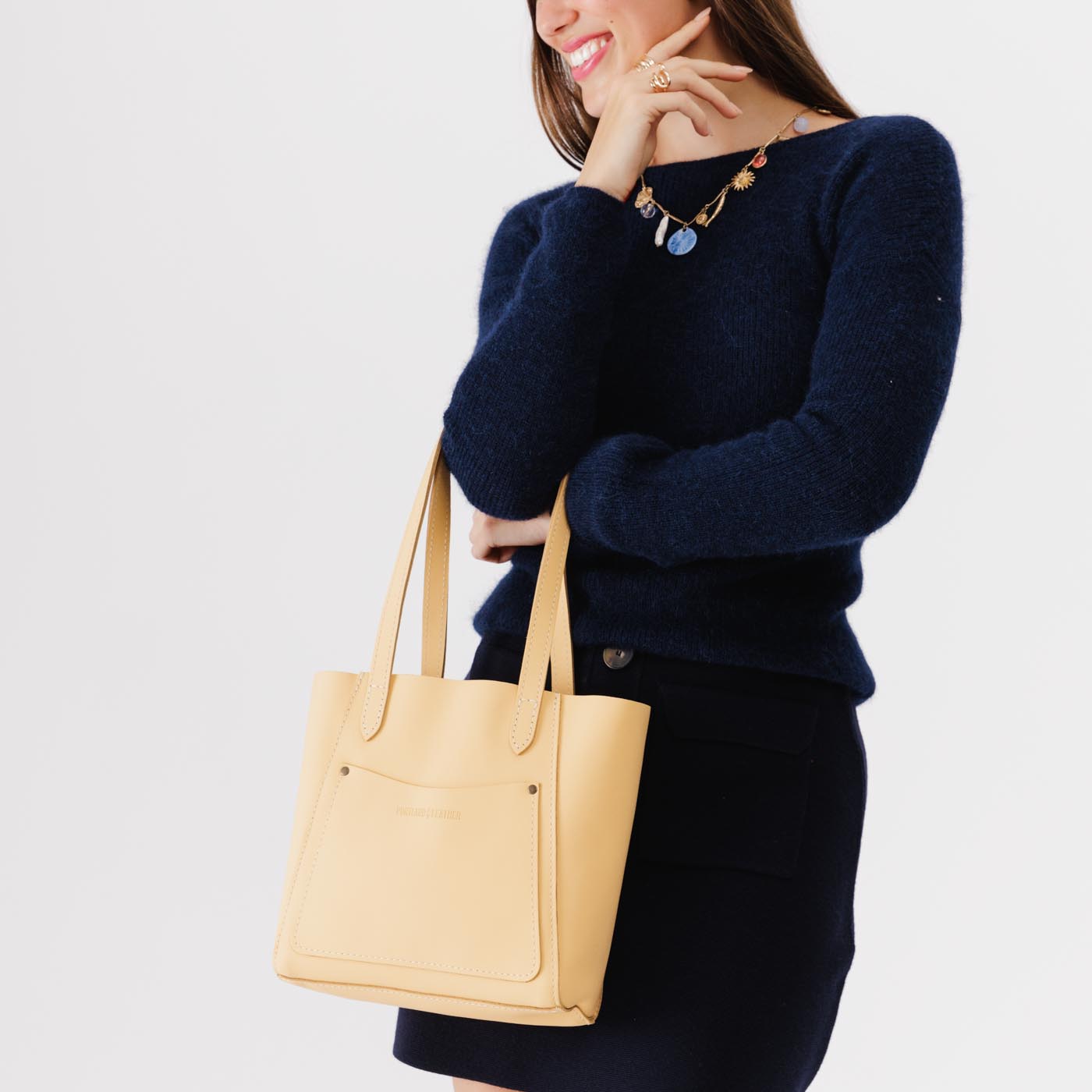 Vanilla*Small | Model holding dual shoulder strap tote bag with an exterior pocket