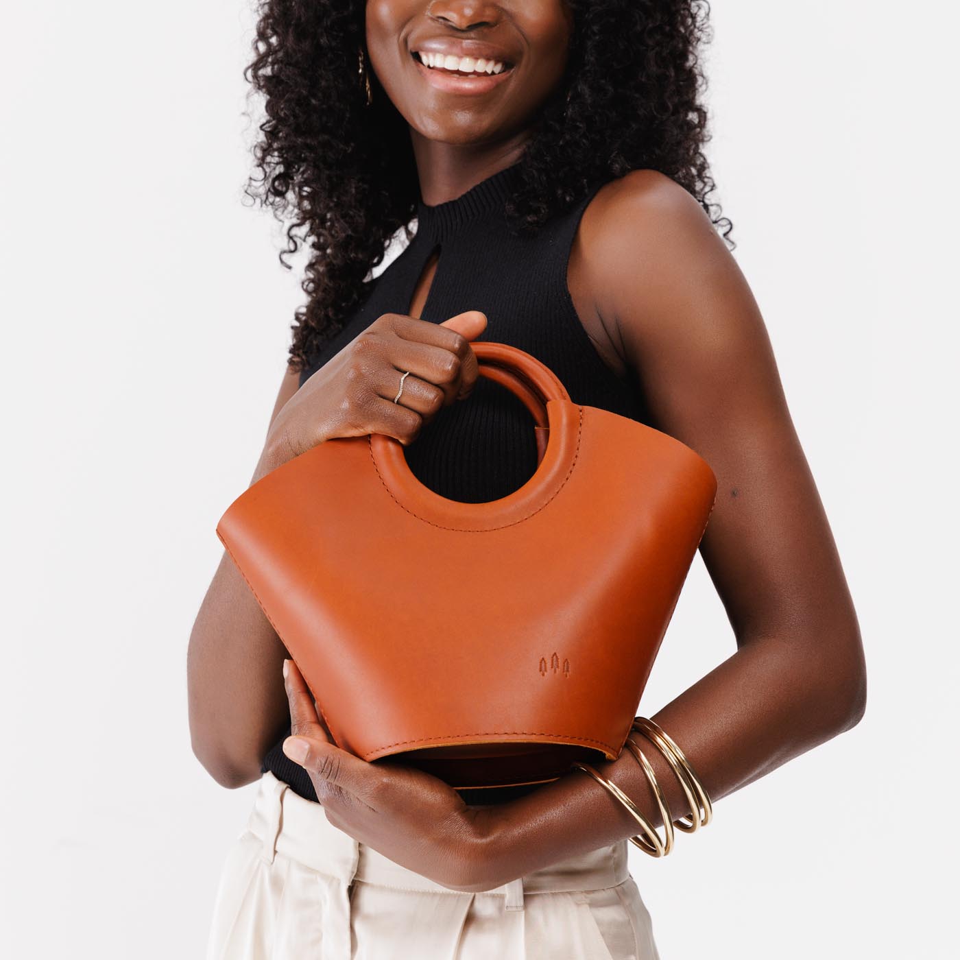 Tuscany Small | Model holding structured leather hand bag with circular handles