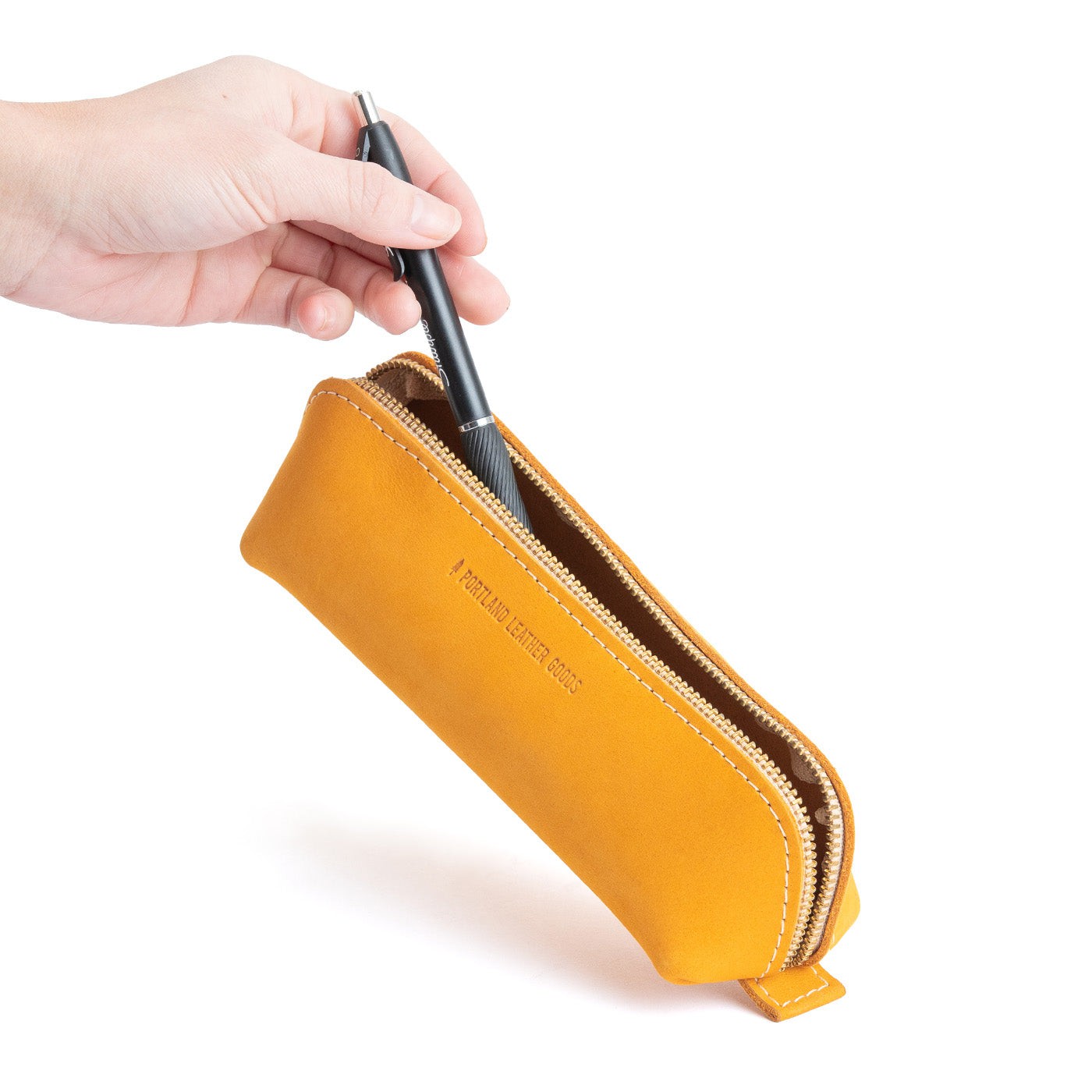 All Color: Turmeric | Leather pouch with curved seams and top zipper