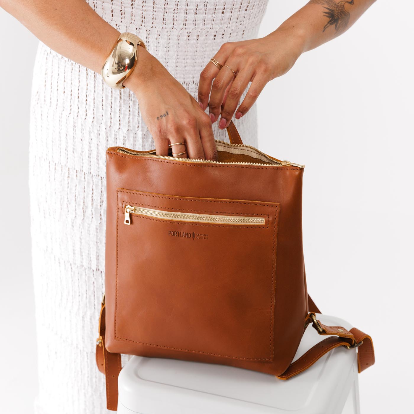 All Color: Honey | Model holding square slim leather tote backpack