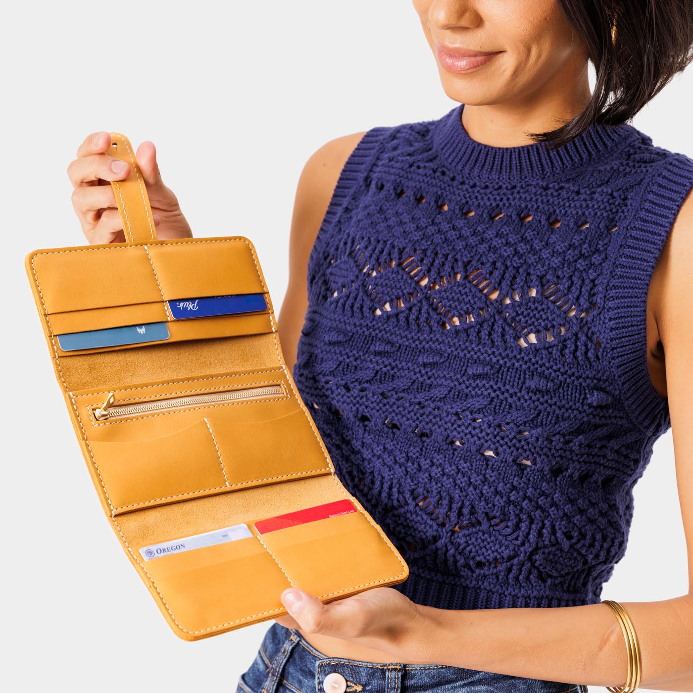 Sunflower | Model holding leather wallet with Sam Browne closure open