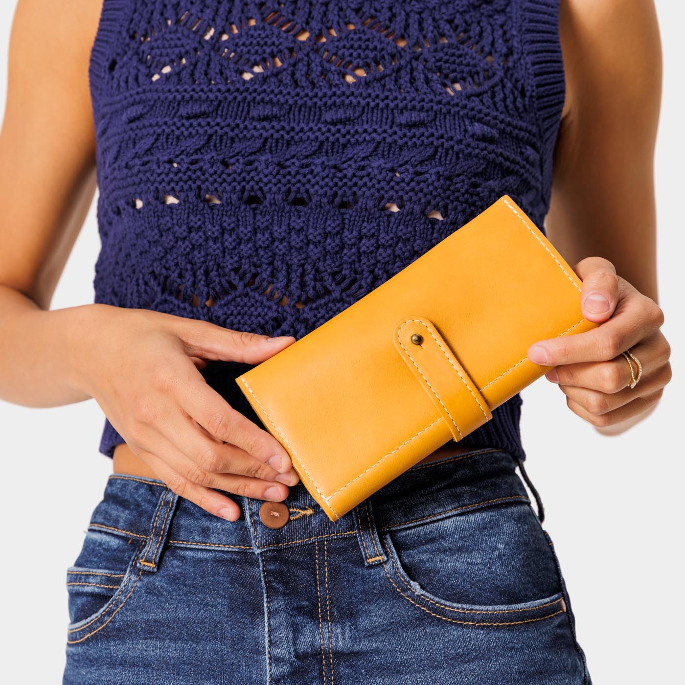 Sunflower | Model holding leather wallet with Sam Browne closure