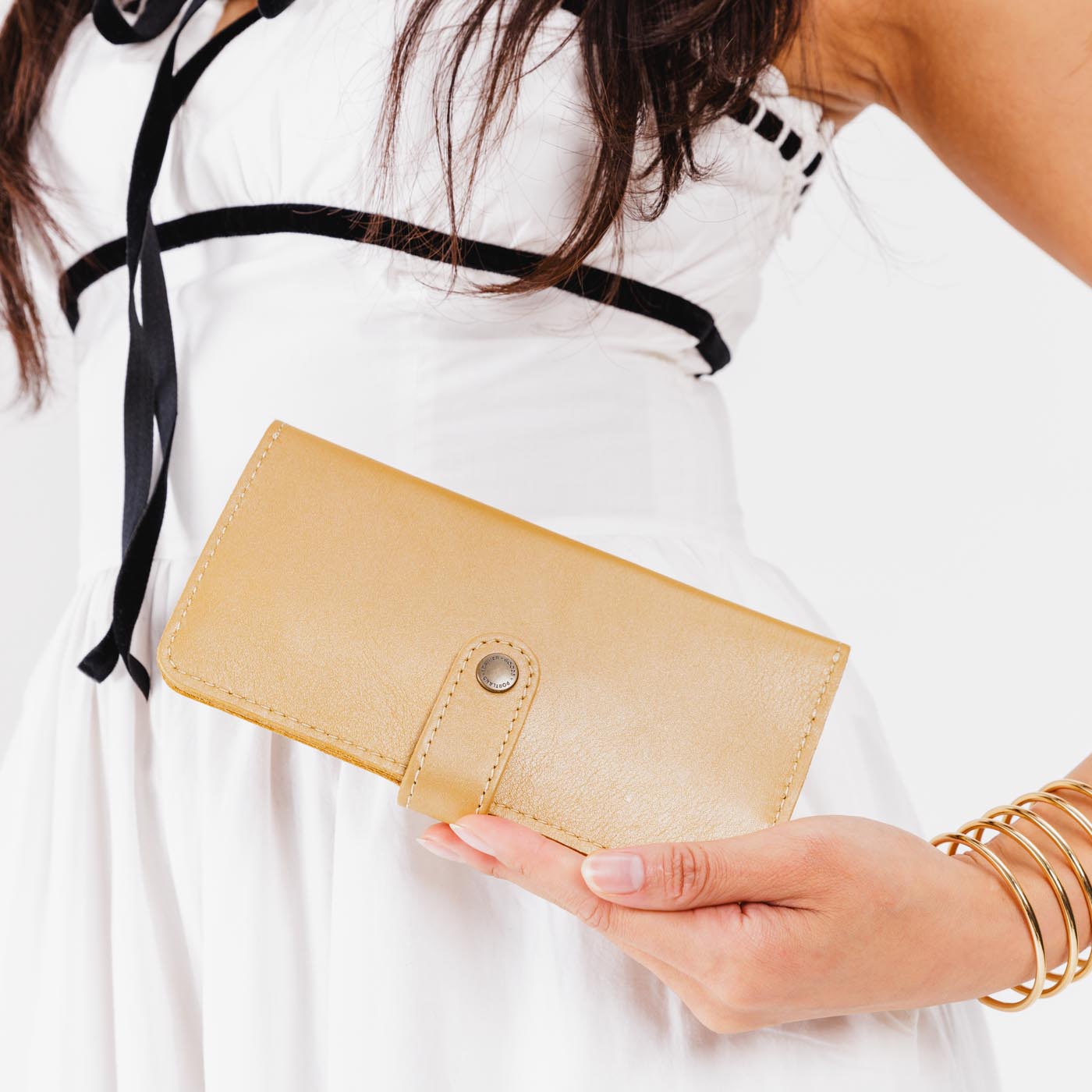 Champagne | Model holding leather wallet with snap closed