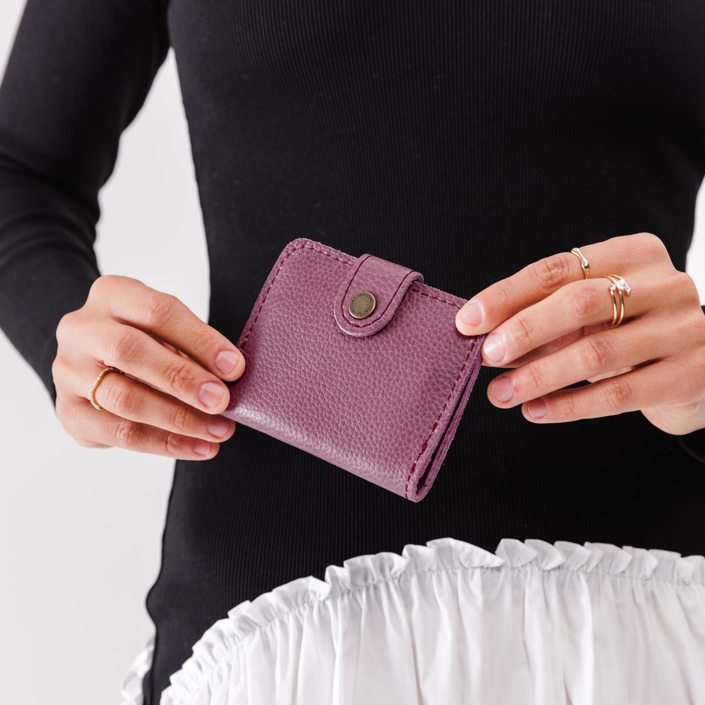 Kyoto | Model holding small leather bifold wallet with snap closed