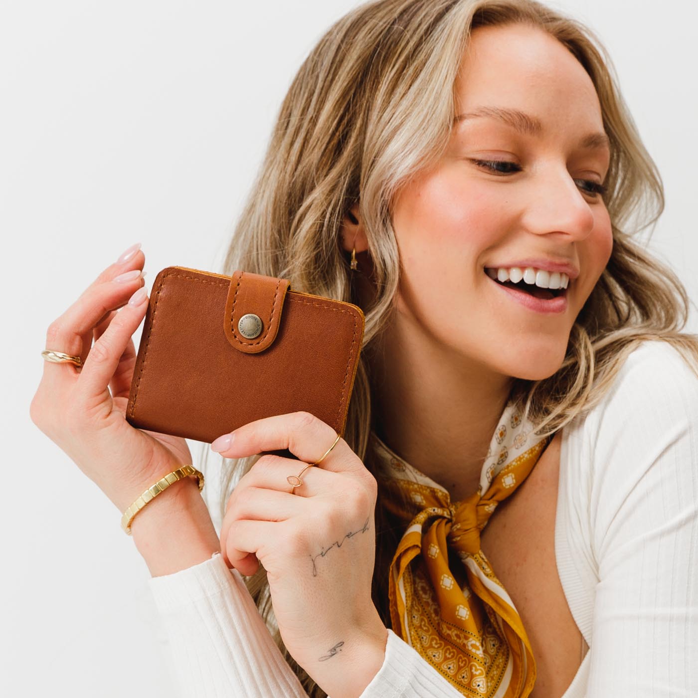 Honey | Model holding small leather bifold wallet with snap closed