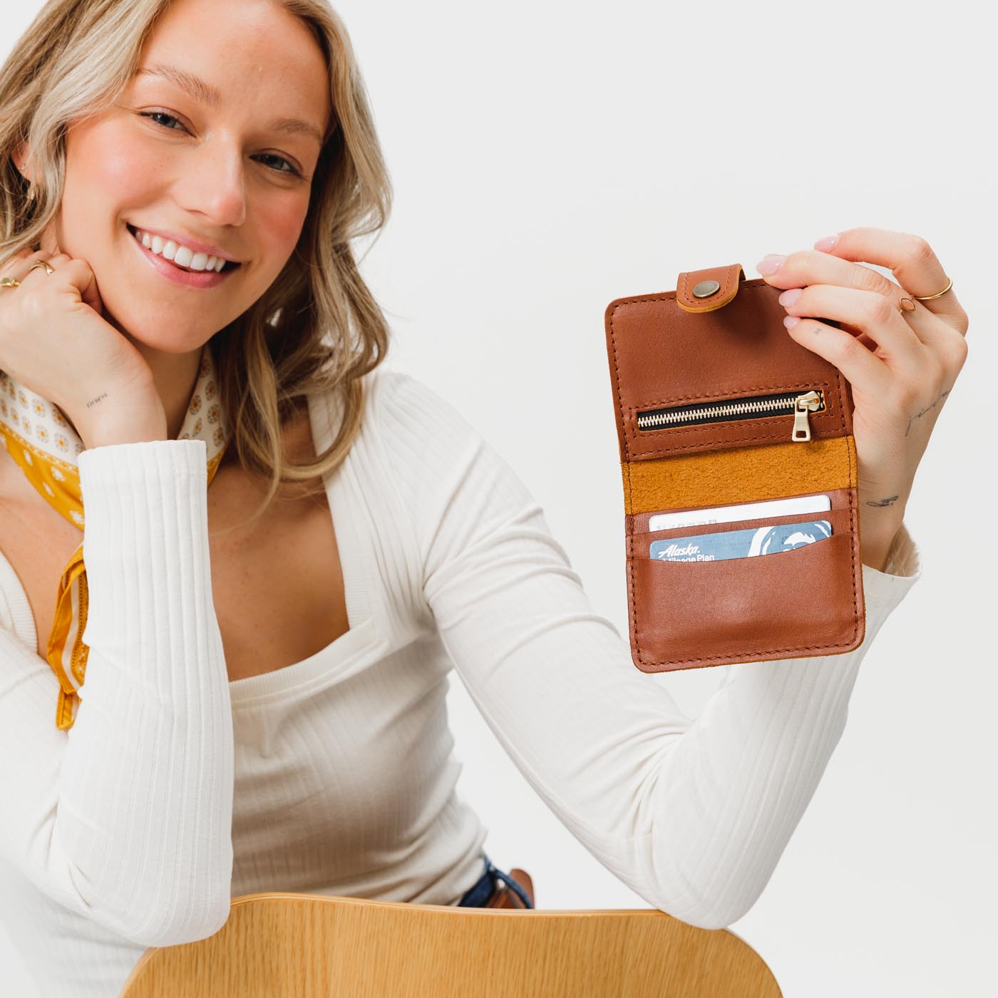 Honey | Model holding small leather bifold wallet with snap open