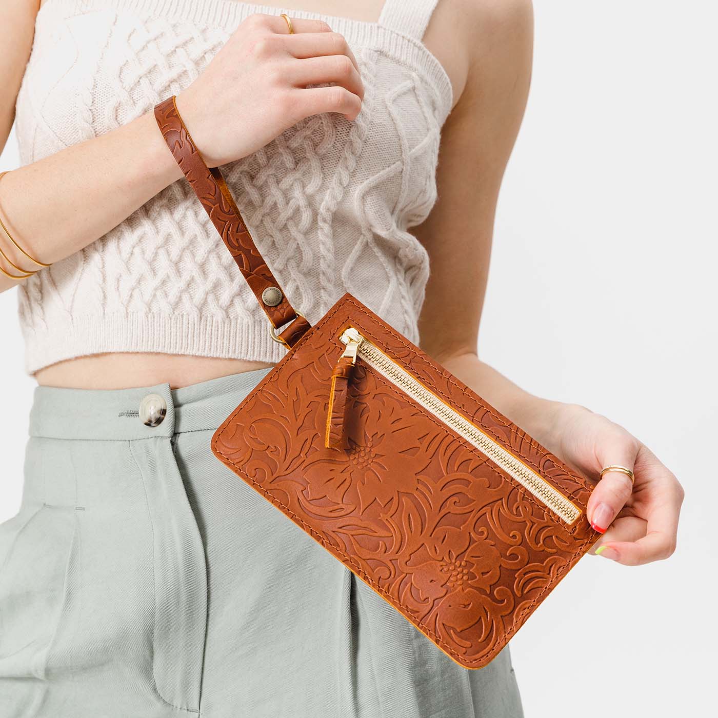 Meadow | Model holding flat leather pouch with zipper and wristlet