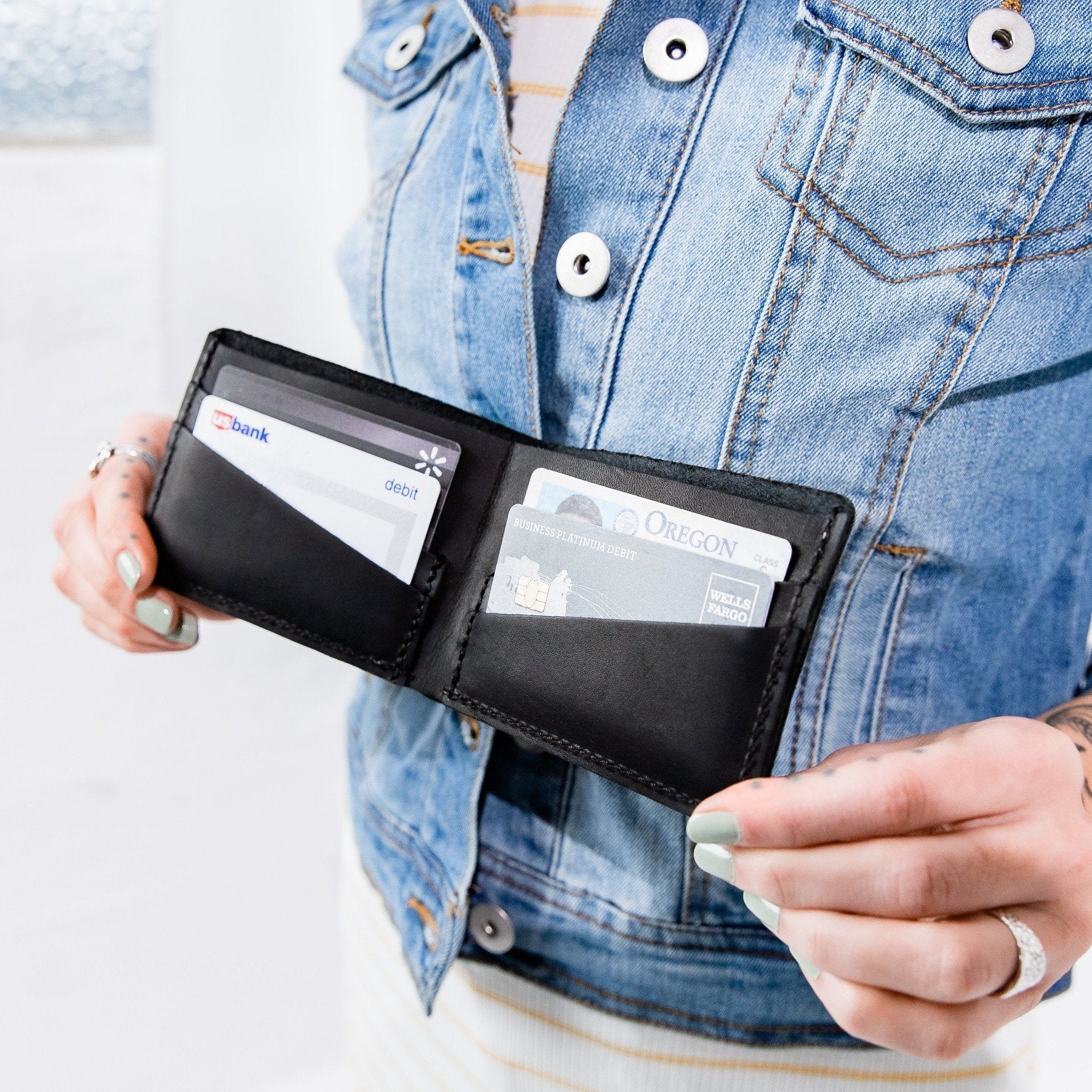 Black | Model holding leather bifold wallet with card slots