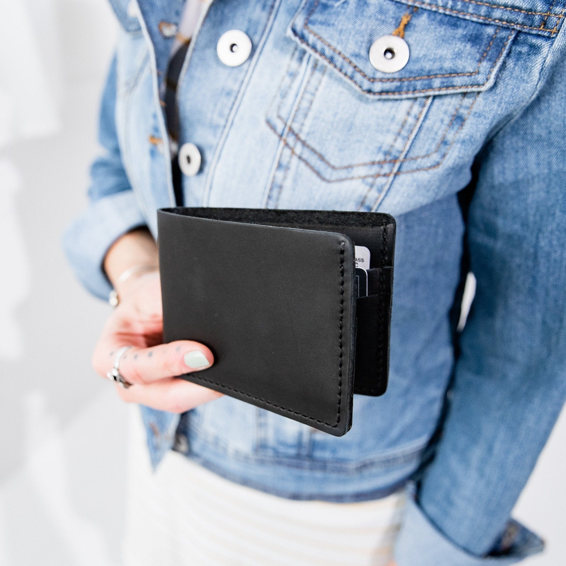 Black | Model holding leather bifold wallet with card slots