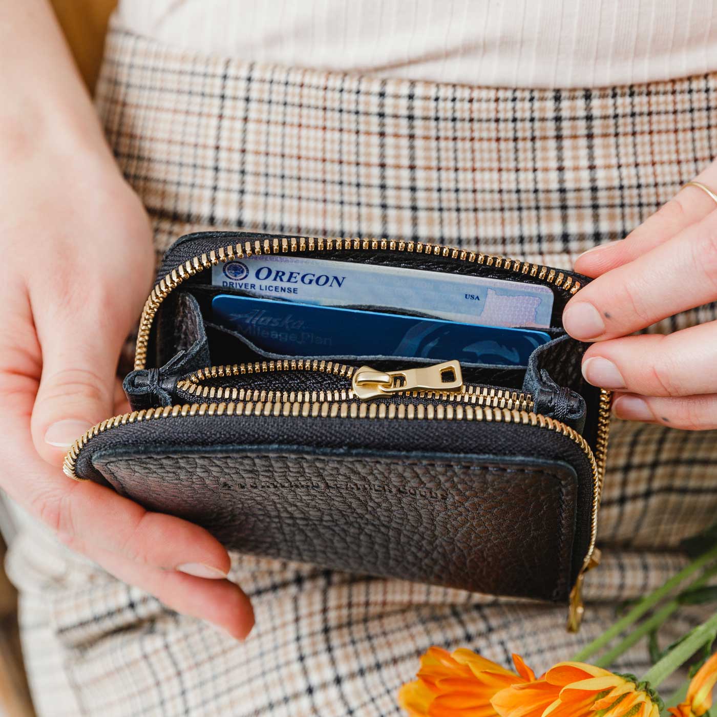 Pebbled--black | Model holding small leather wallet with zipper open