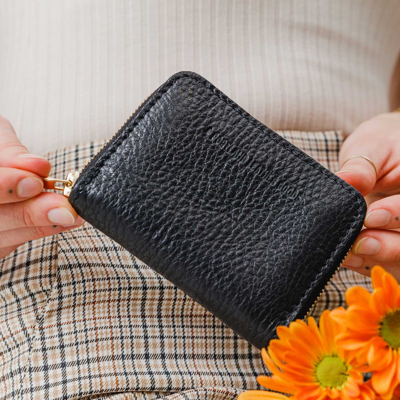 Pebbled--black | Model holding small leather wallet with zipper closed