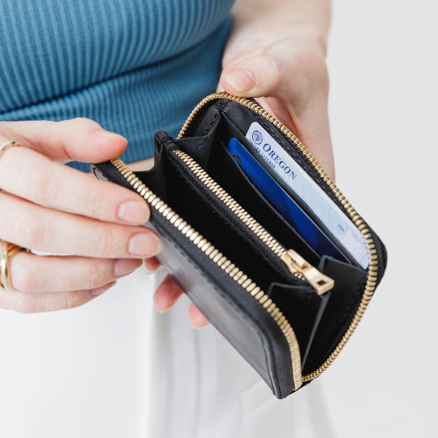 Black | Model holding small leather wallet with zipper open