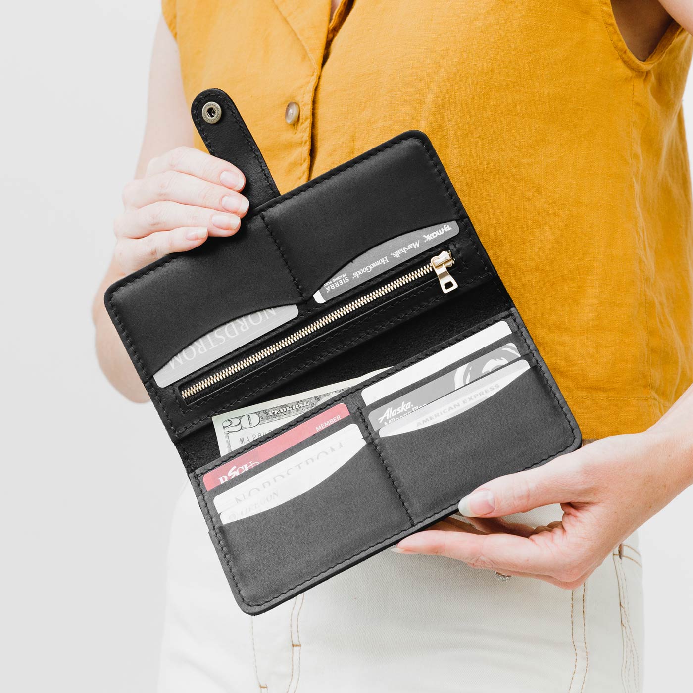 Black | Model holding leather wallet with snap open