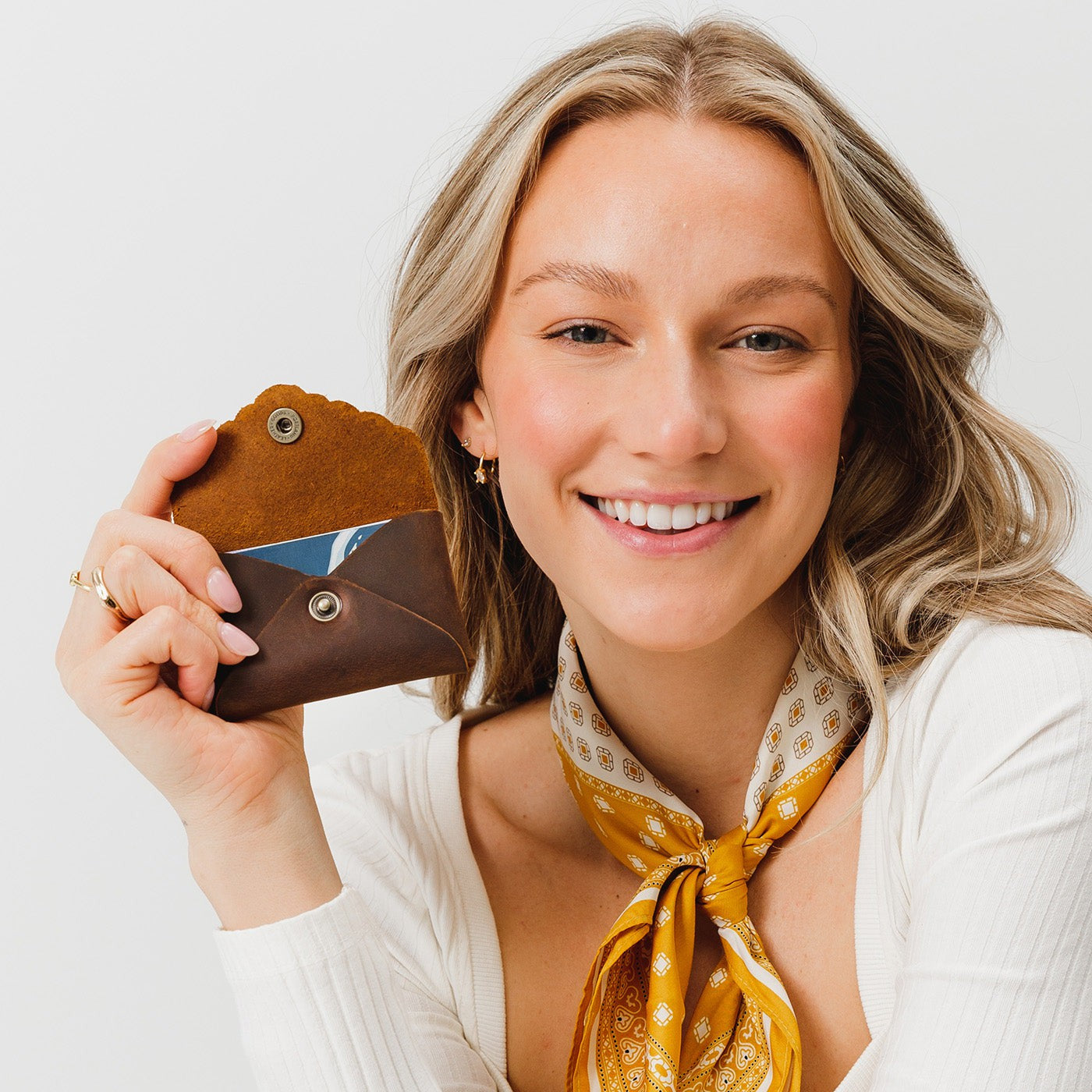 Canyon | Model holding small leather wallet with scalloped edge open