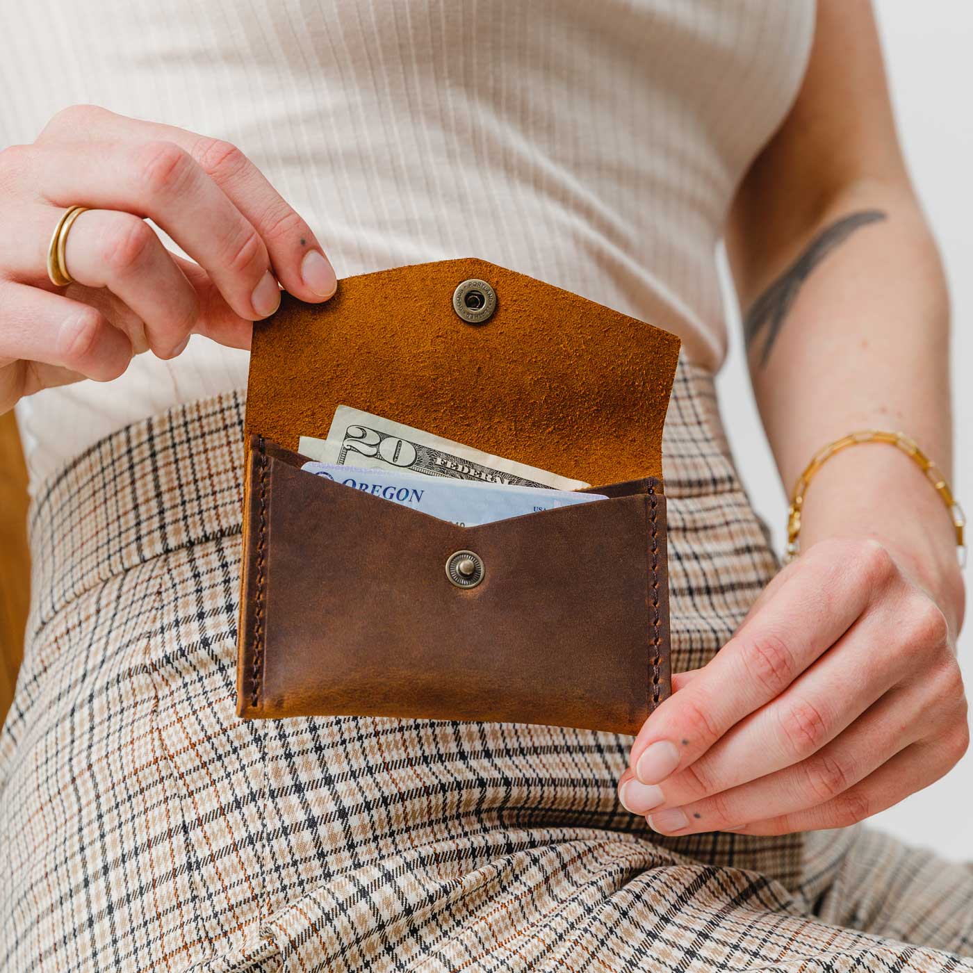 Canyon | Model holding small leather envelope wallet with snap closure open