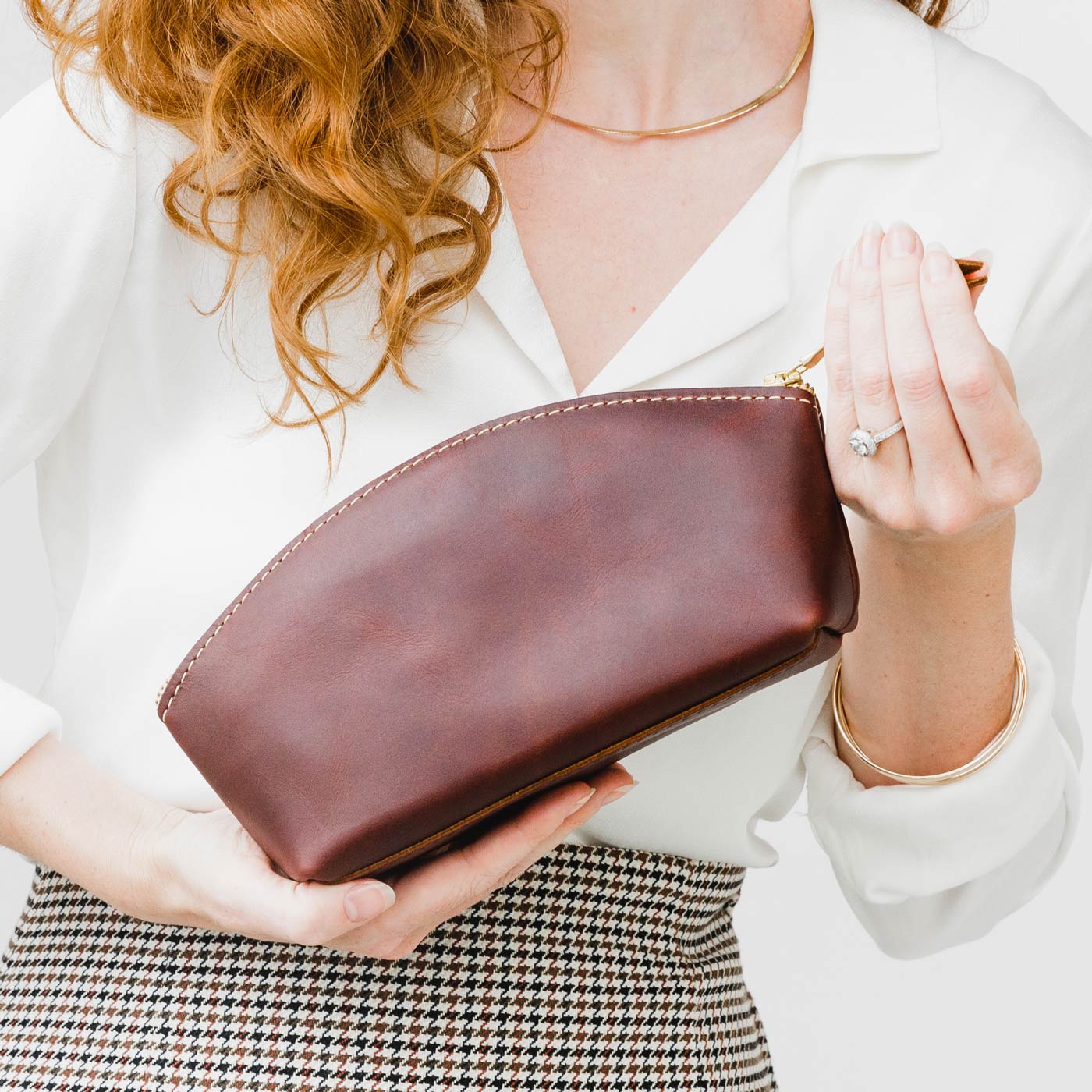 All Color: Cognac | Spacious leather makeup bag with curved seams and top zipper