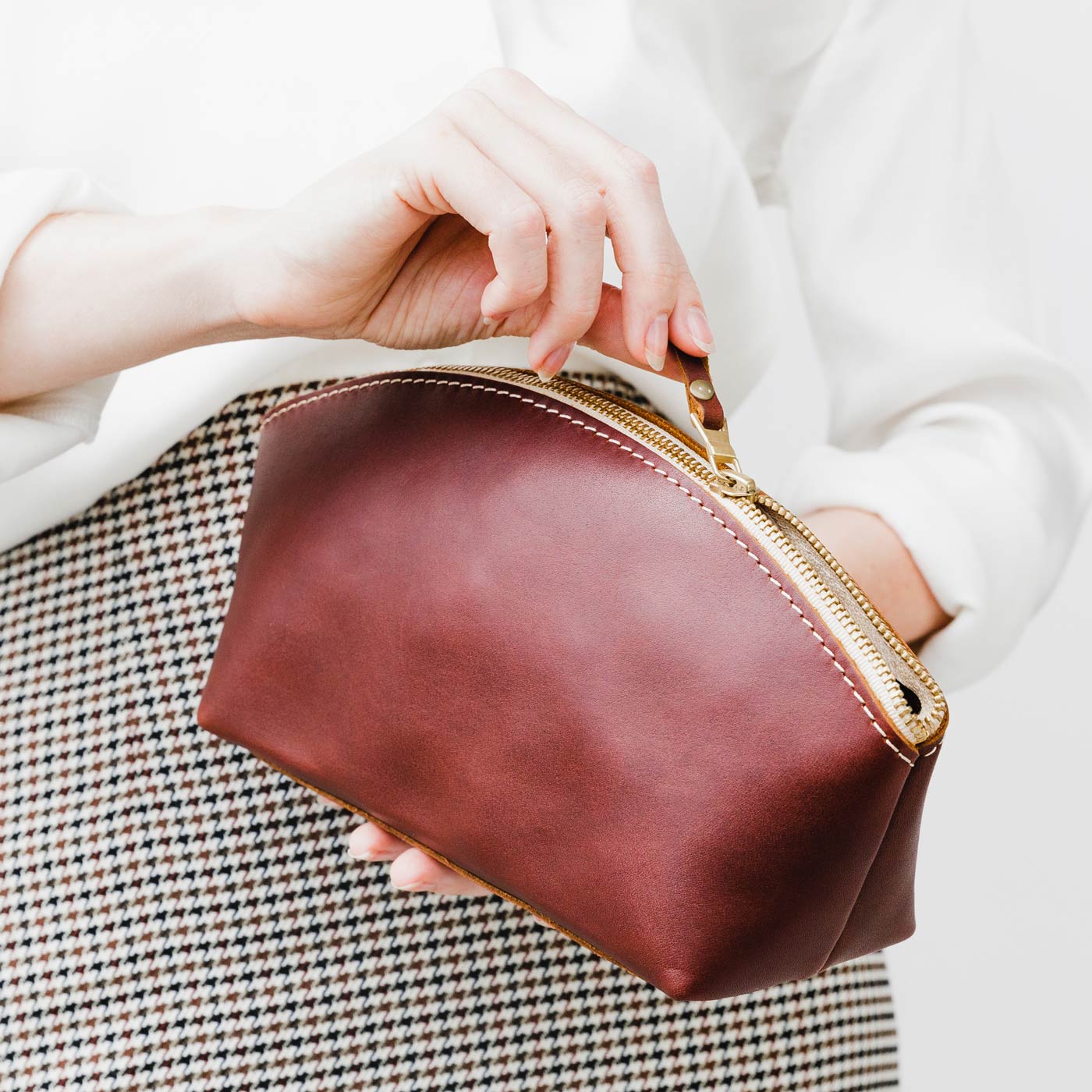 All Color: Cognac | Spacious leather makeup bag with curved seams and top zipper