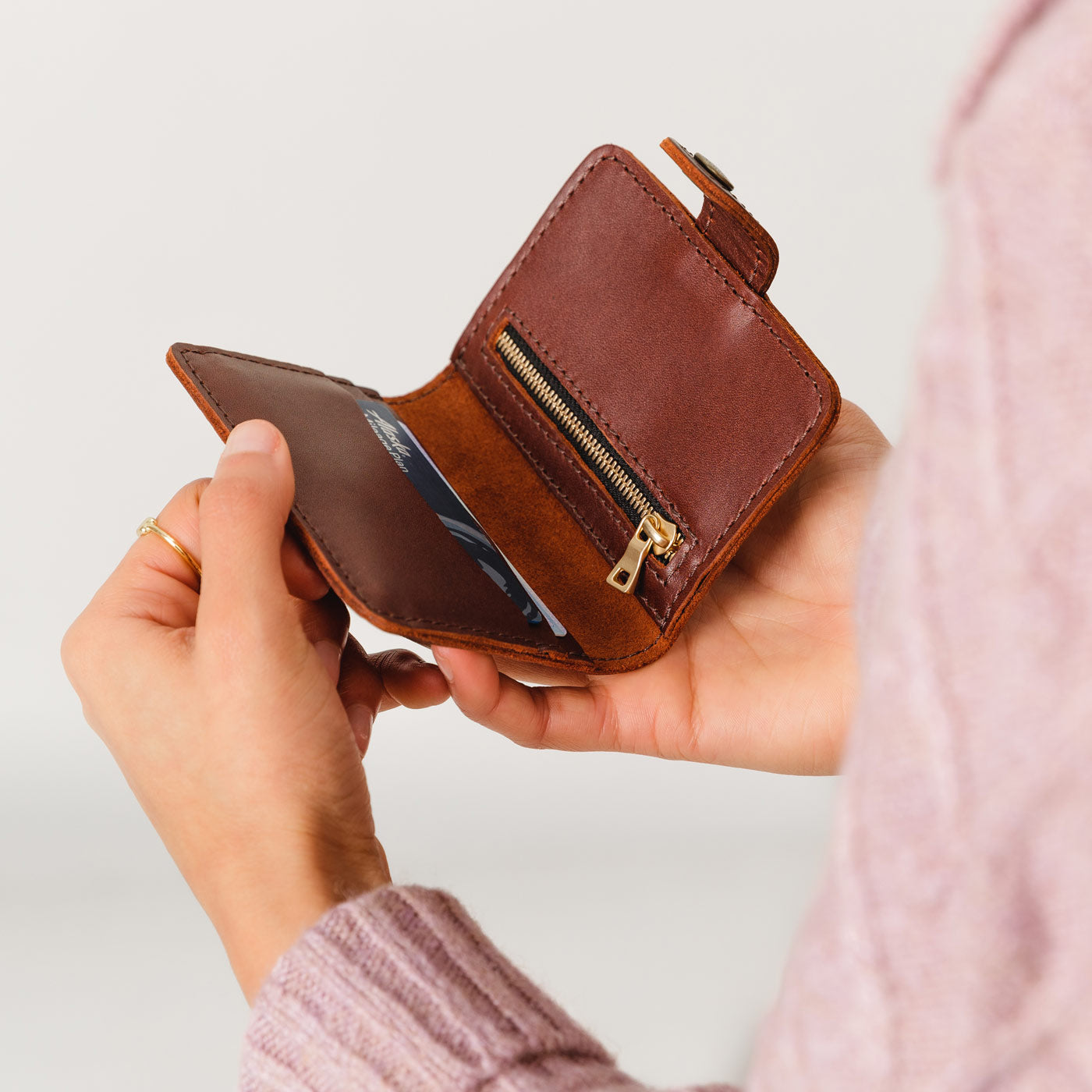 Cognac | Model holding small leather bifold wallet with snap open