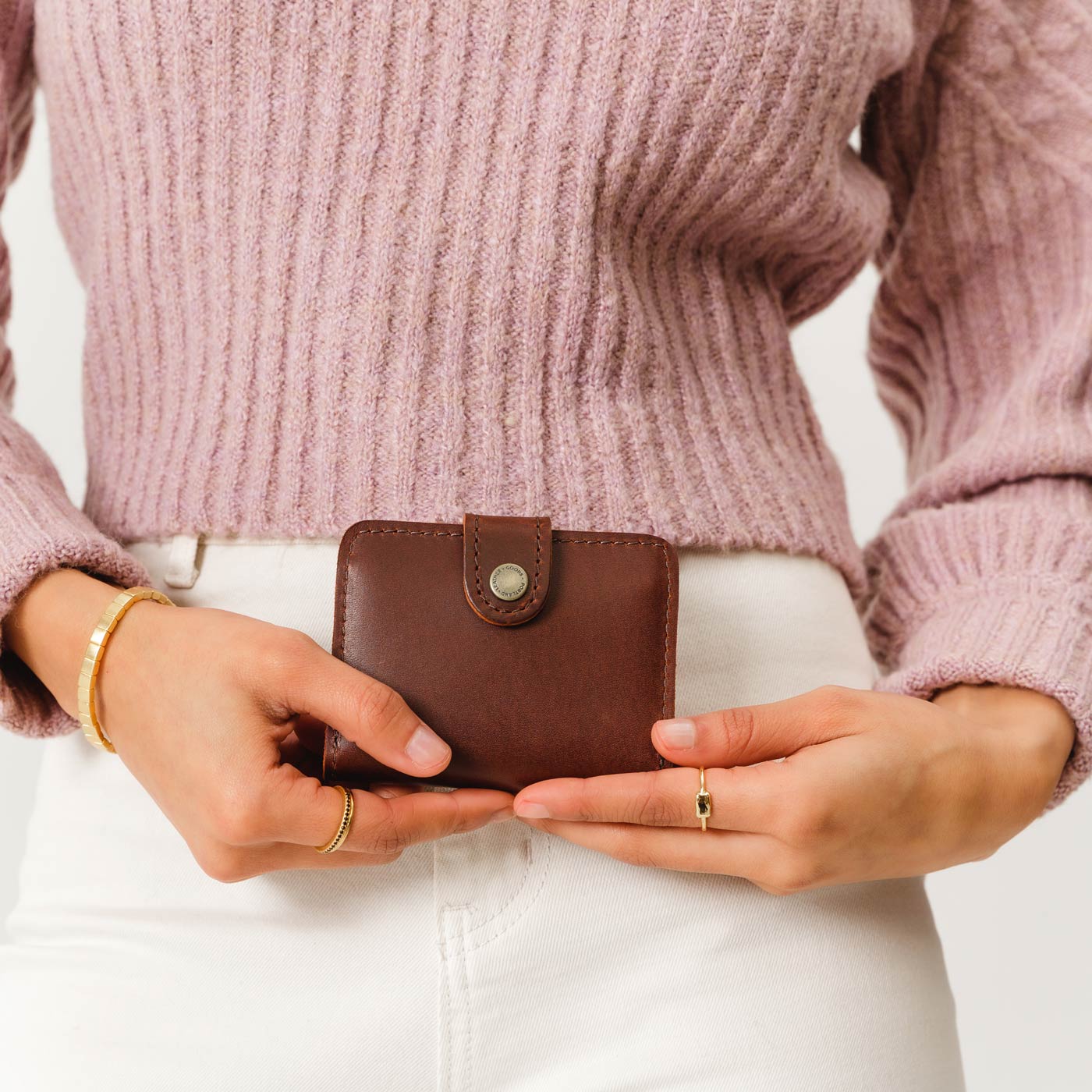 Cognac | Model holding small leather bifold wallet with snap closed