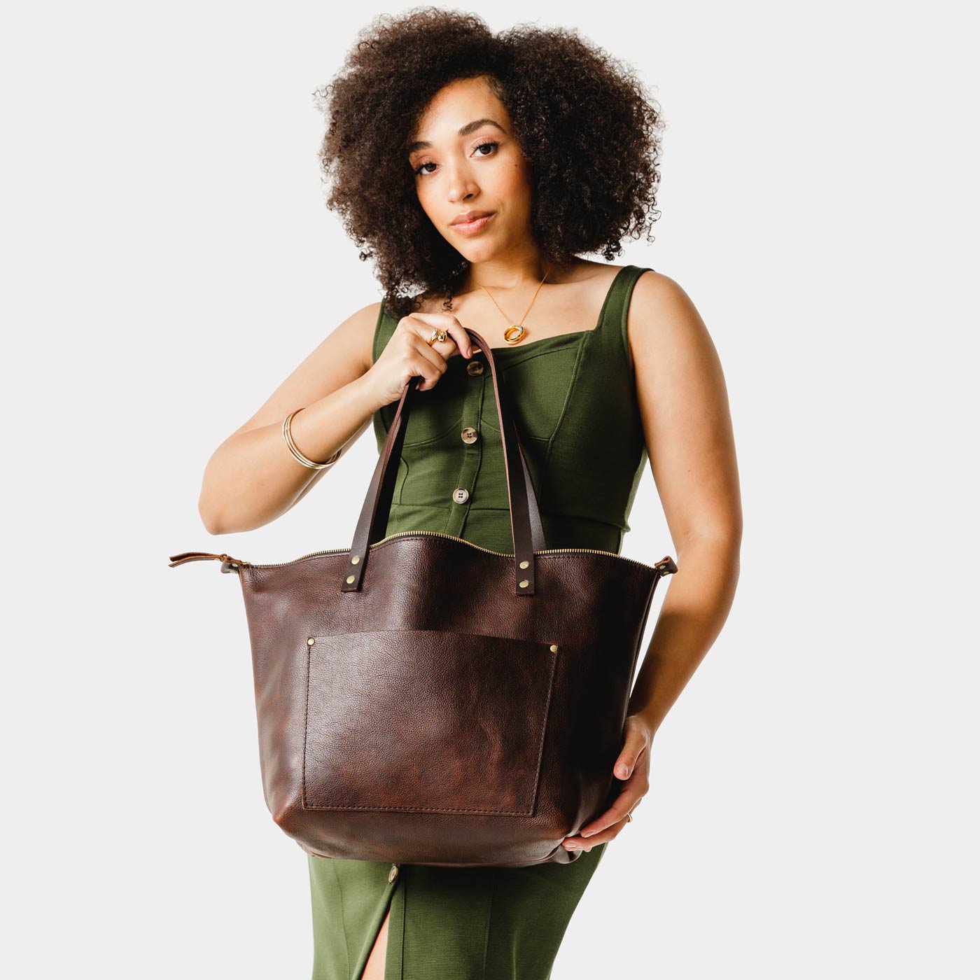 Coldbrew*Zipper | Model holding large zipper leather tote bag with sturdy bridle handles and front pocket