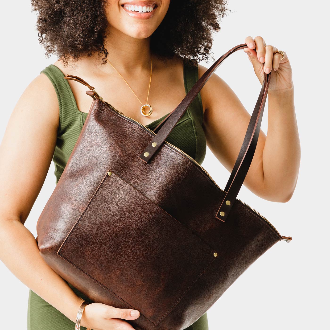 Coldbrew*Zipper | Model holding large zipper leather tote bag with sturdy bridle handles and front pocket