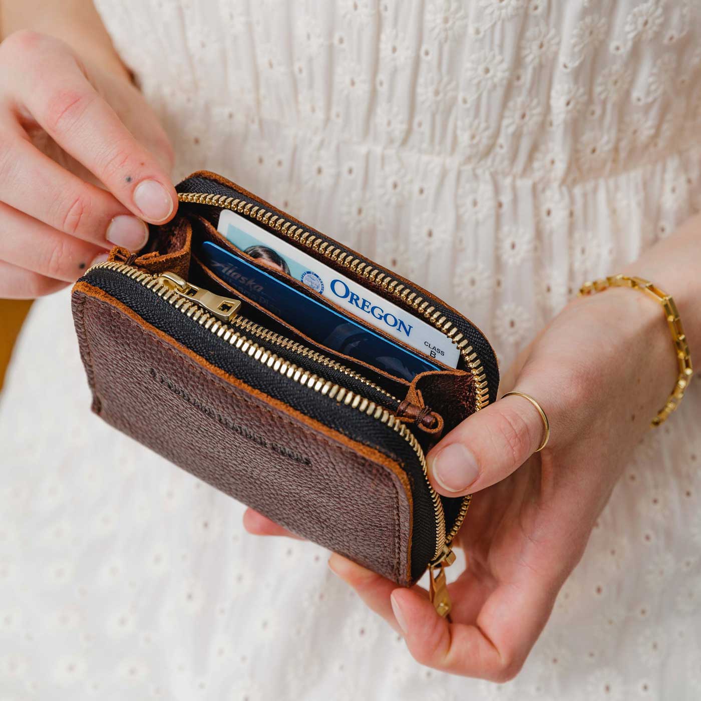 Coldbrew | Model holding small leather wallet with zipper open