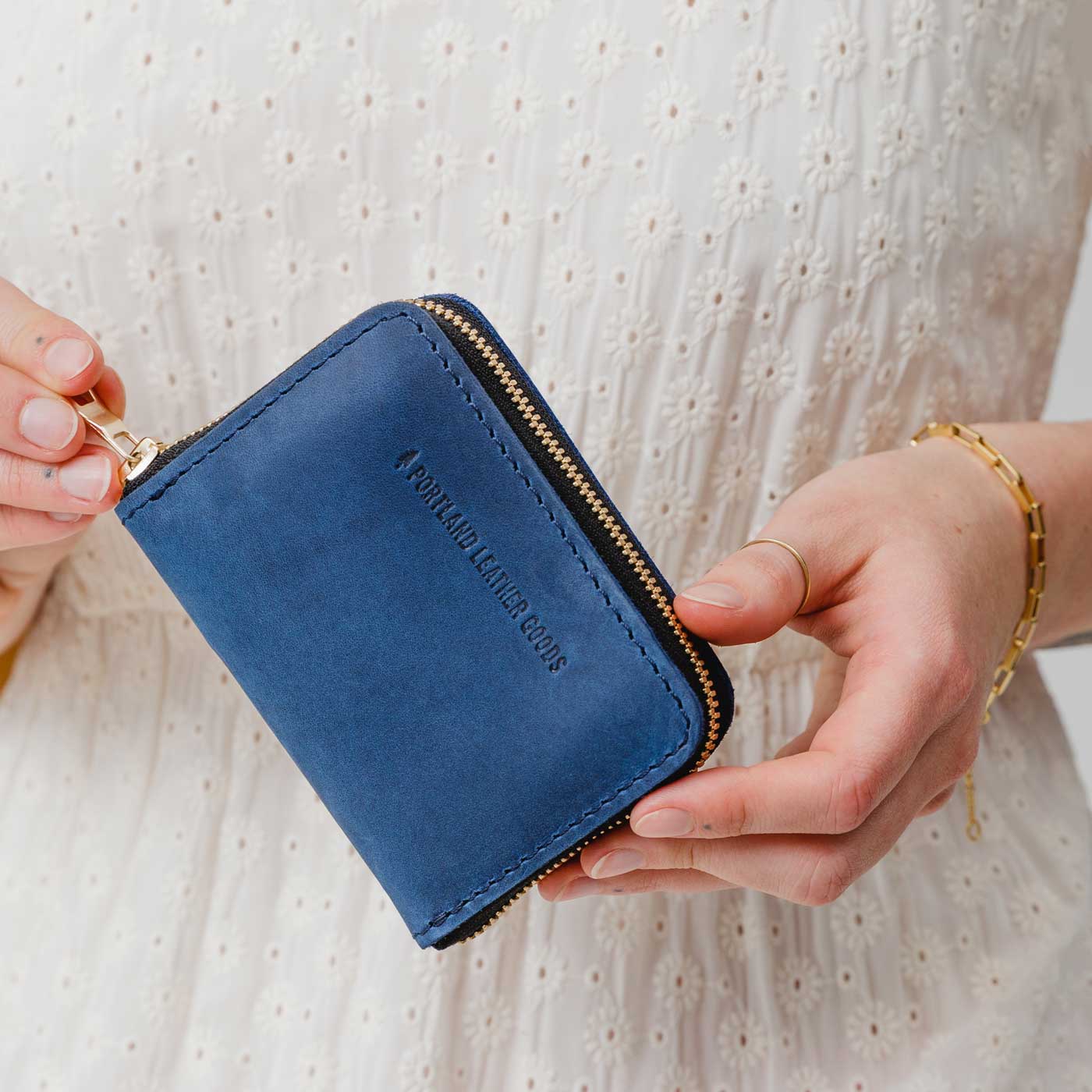 Deep Water | Model holding small leather wallet with zipper closed