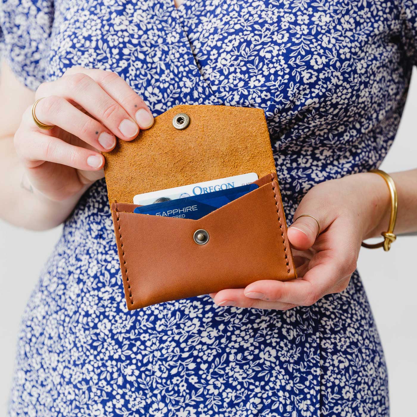 Honey | Model holding small leather envelope wallet with snap closure open