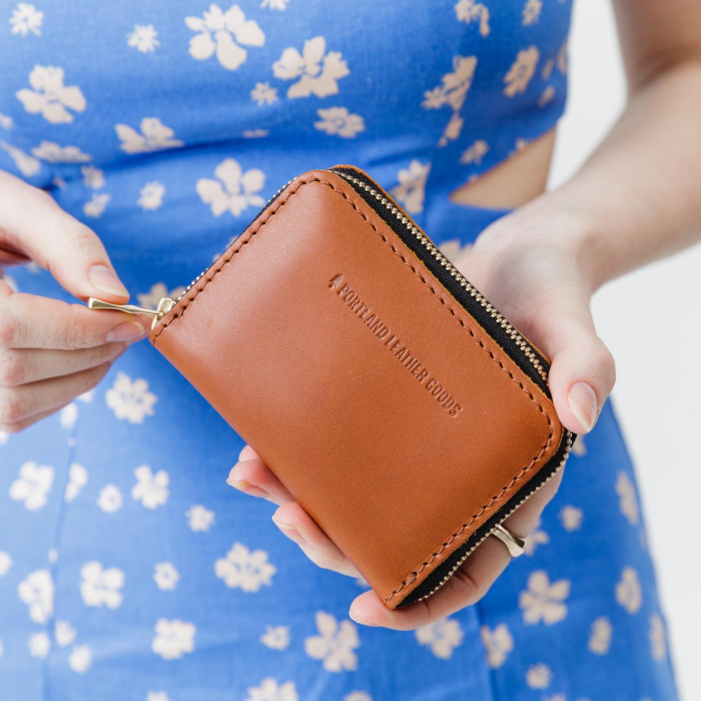 Honey | Model holding small leather wallet with zipper closed