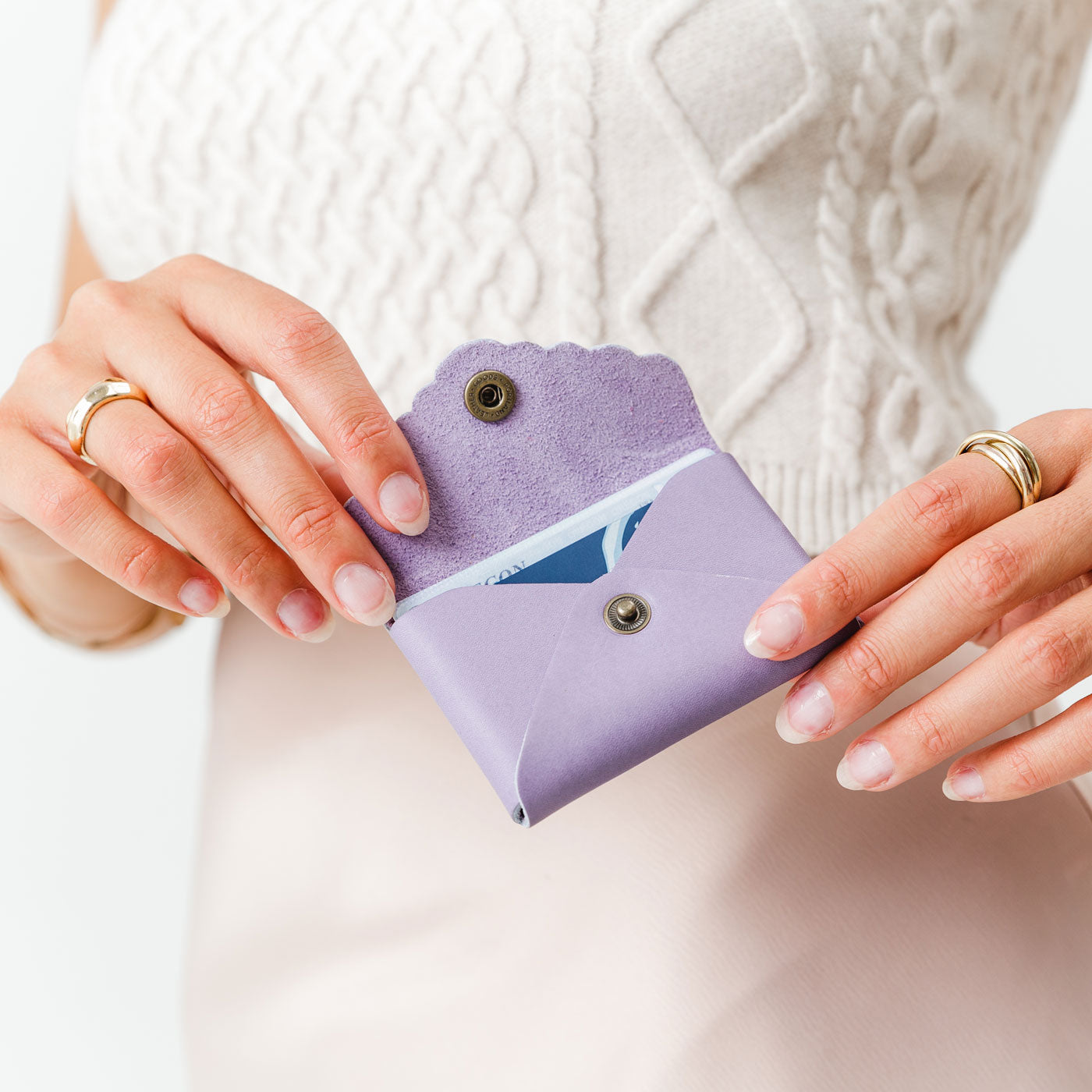 Lavender | Model holding small leather wallet with scalloped edge open