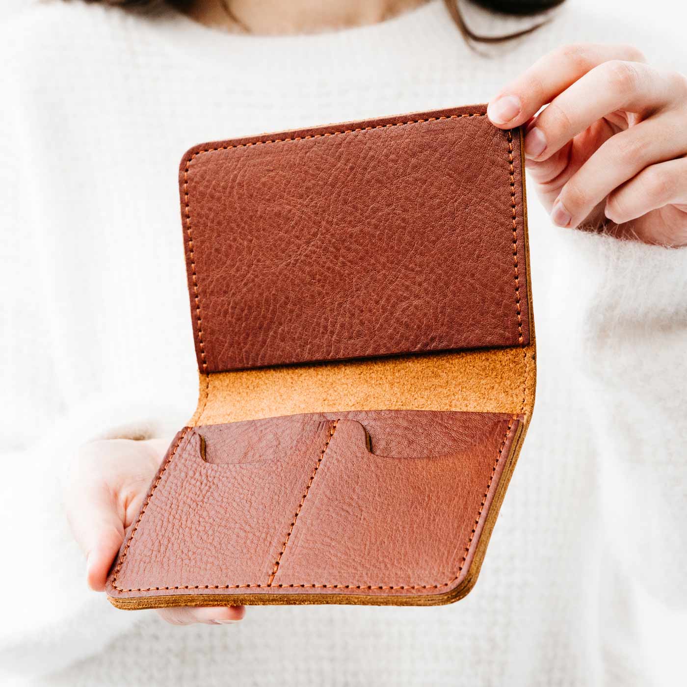 Nutmeg | Model holding leather passport case with PLG logo