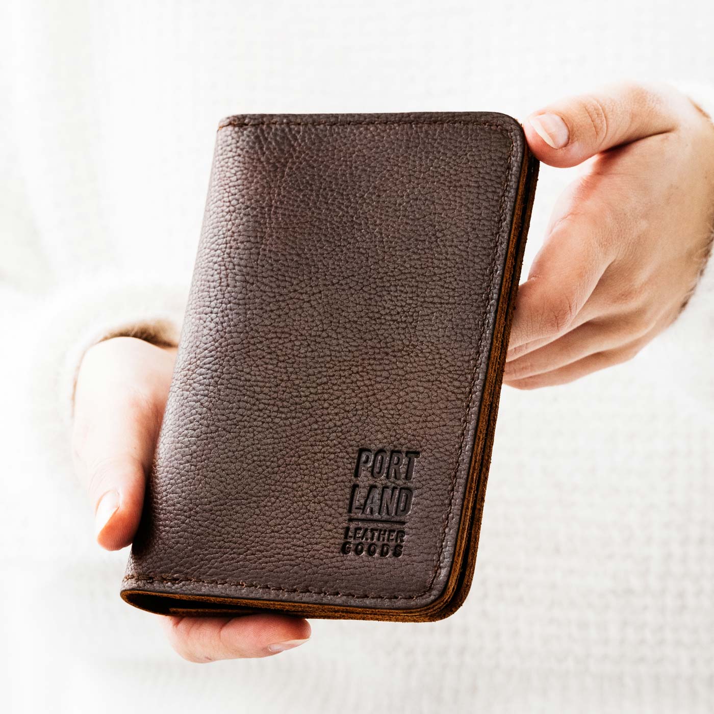 Coldbrew | Model holding leather passport case with PLG logo