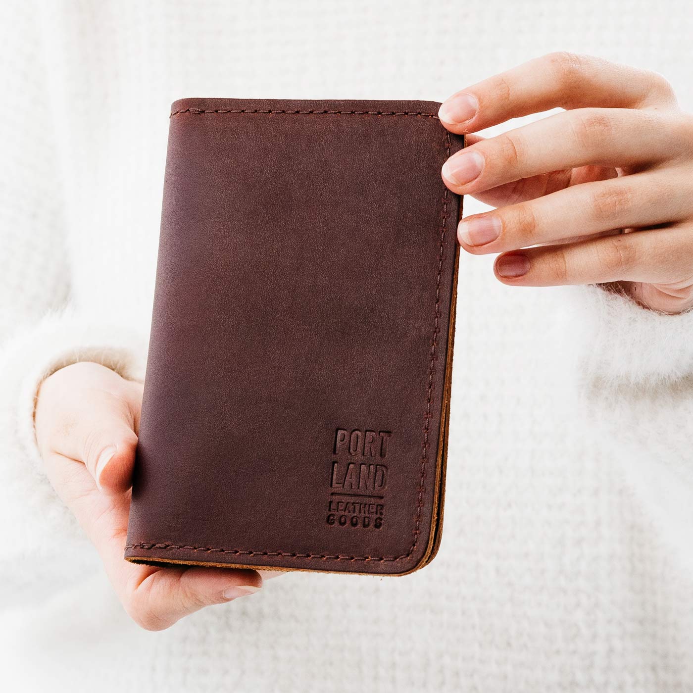 Cognac | Model holding leather passport case with PLG logo