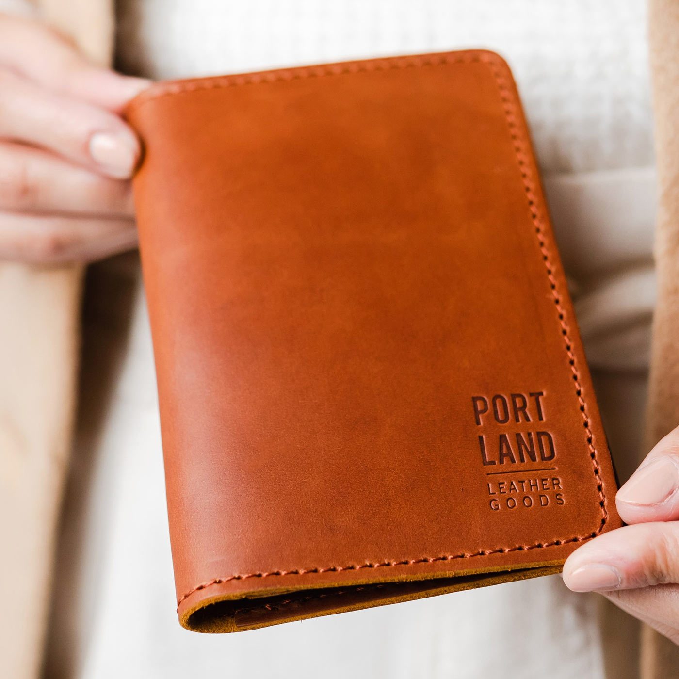 Honey | Model holding leather passport case with PLG logo