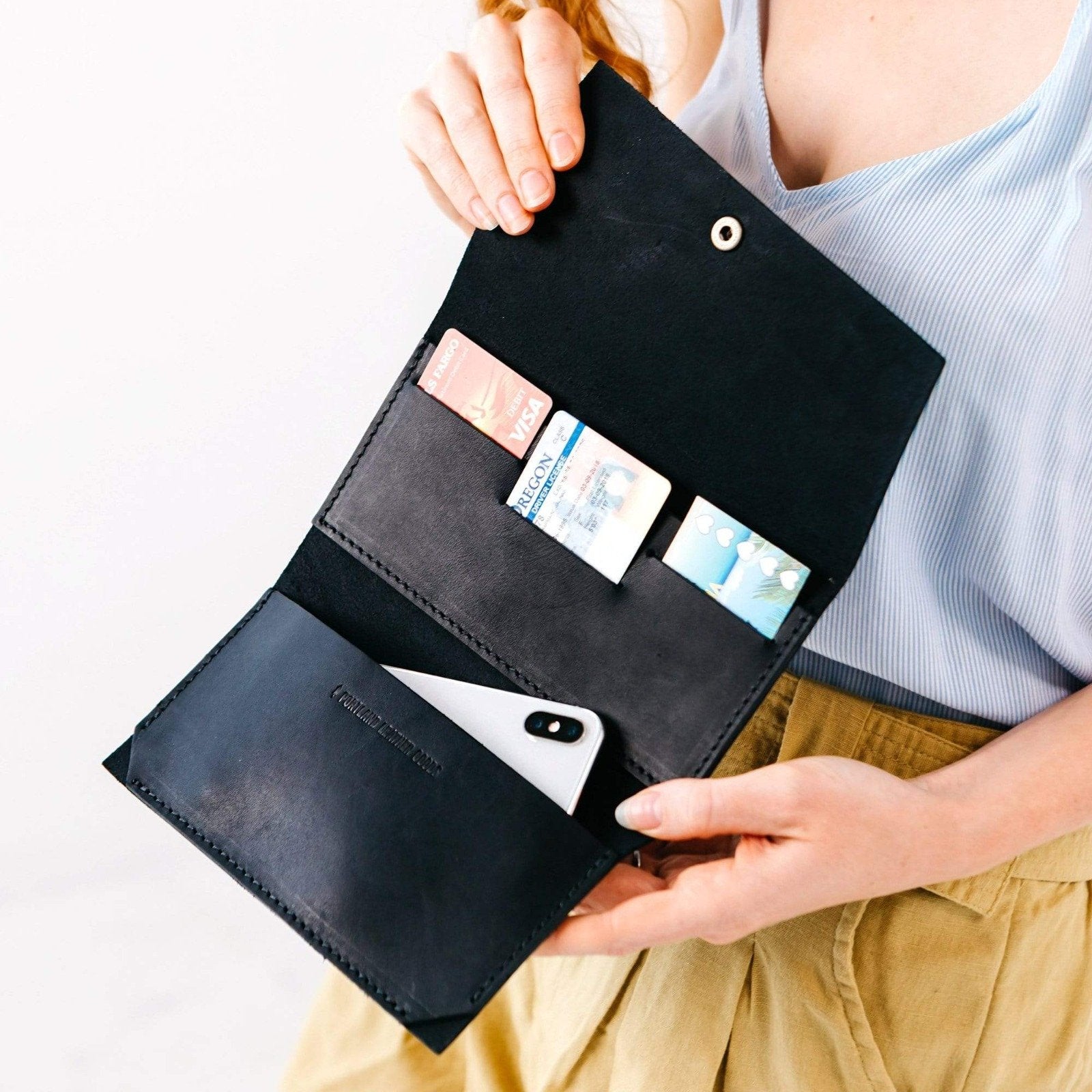 Black | Model holding leather wallet with snap closure open